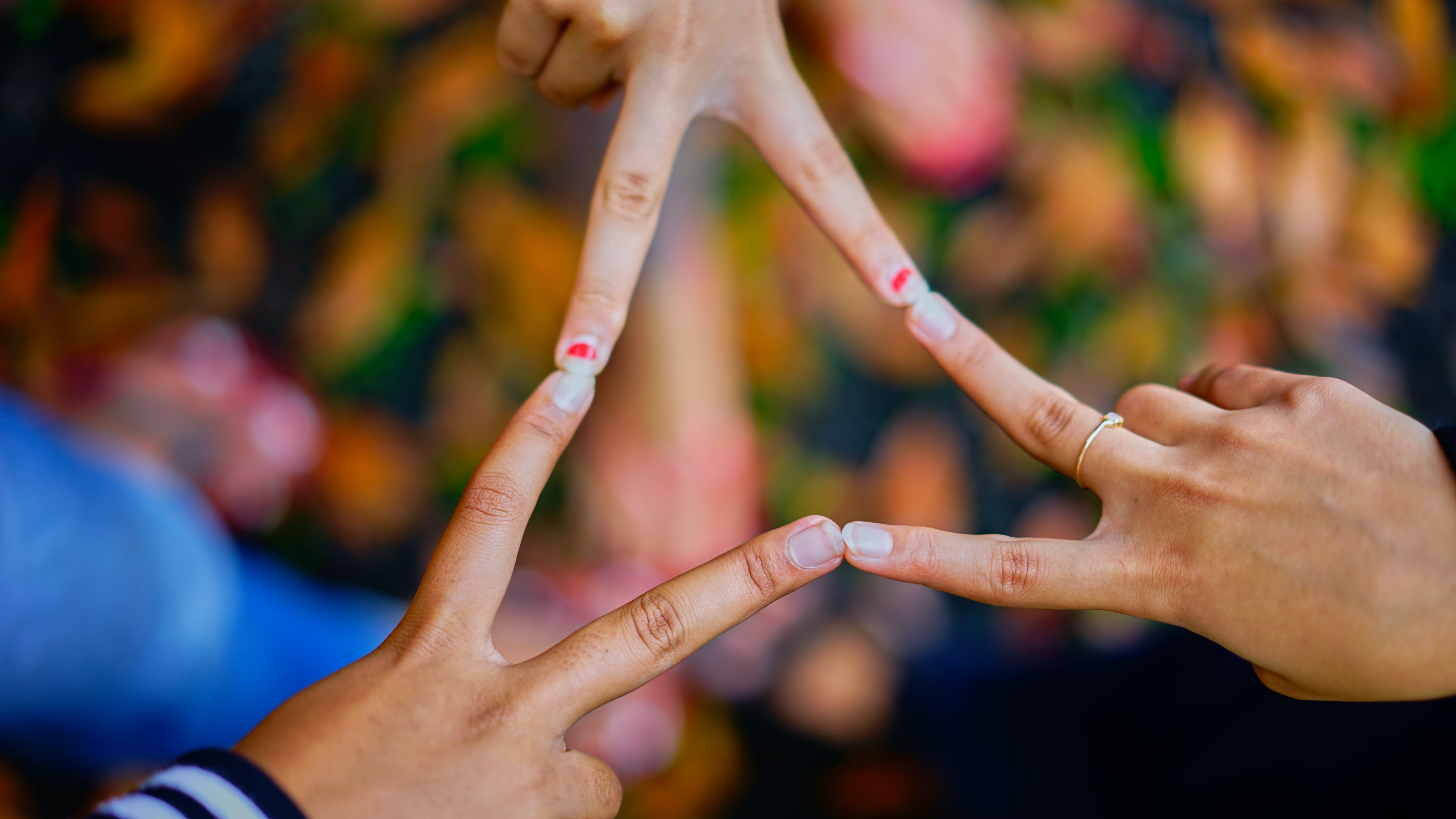 three hands coming together to form triangle