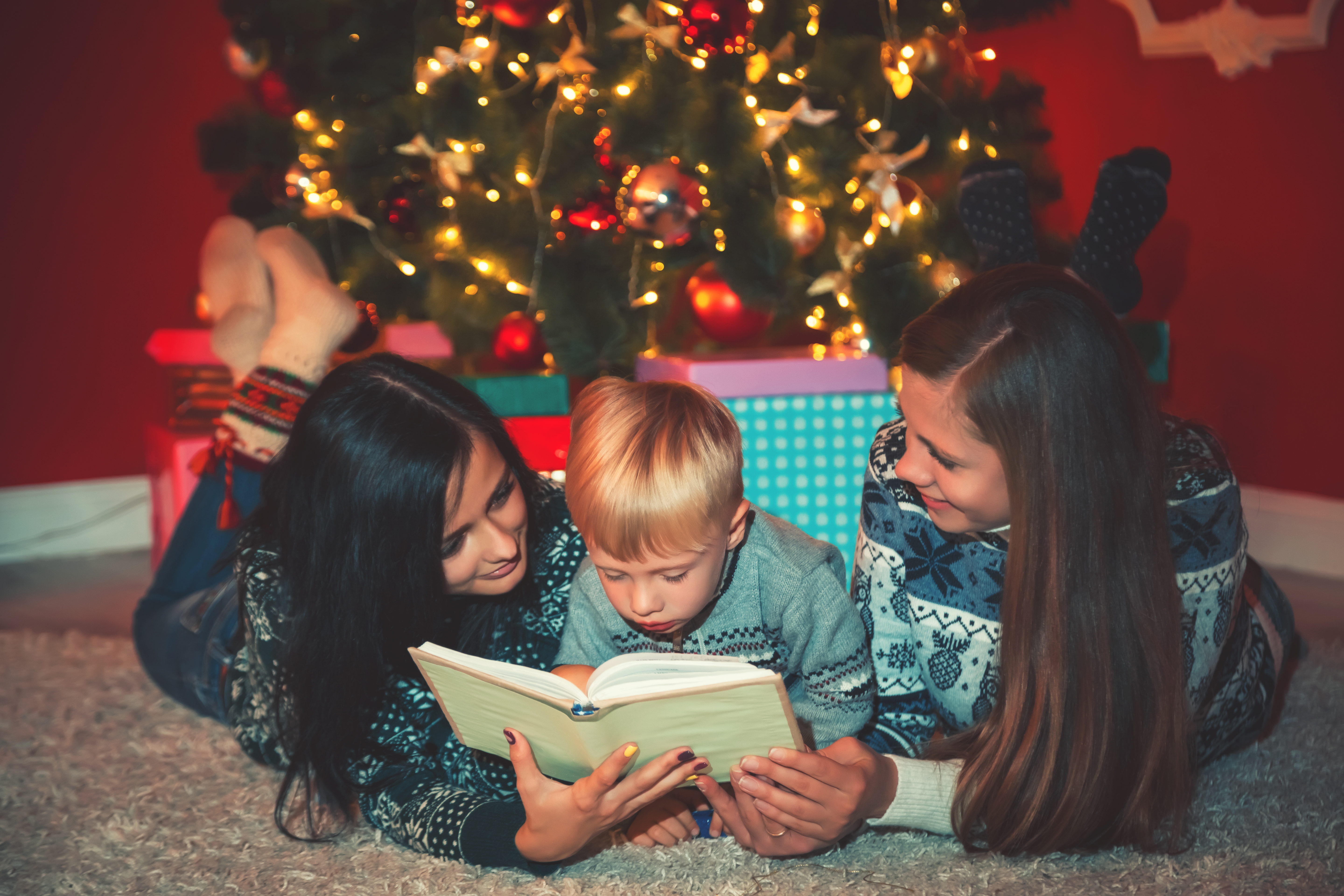 Children reading under the Christmas tree