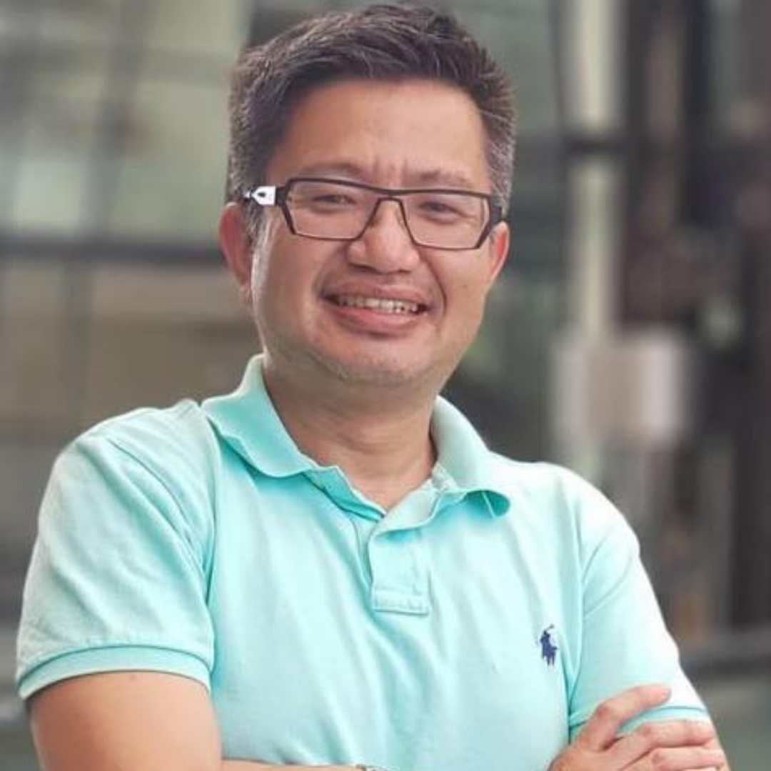 Alfred Kah Meng Pang in a light teal shirt with glasses on