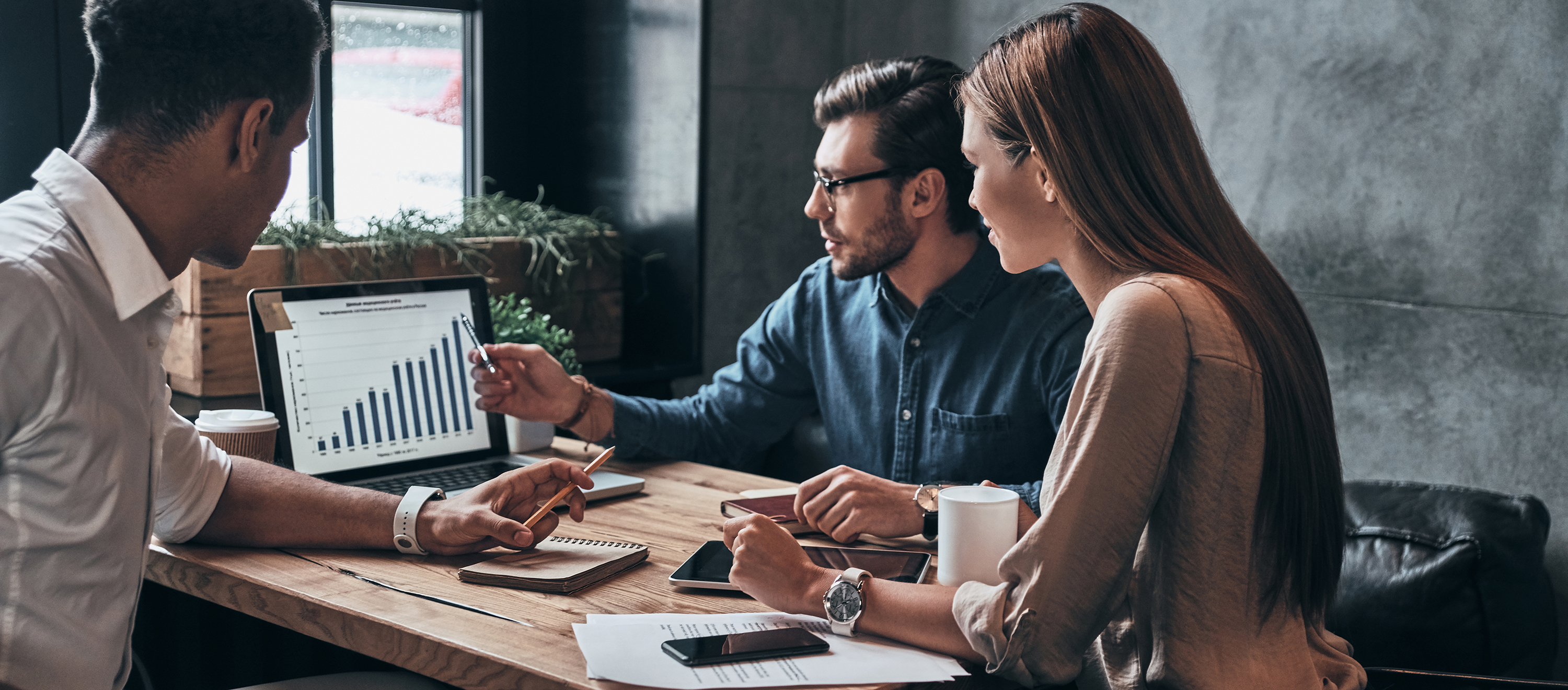 Two males and a female sales professionals review a forecast