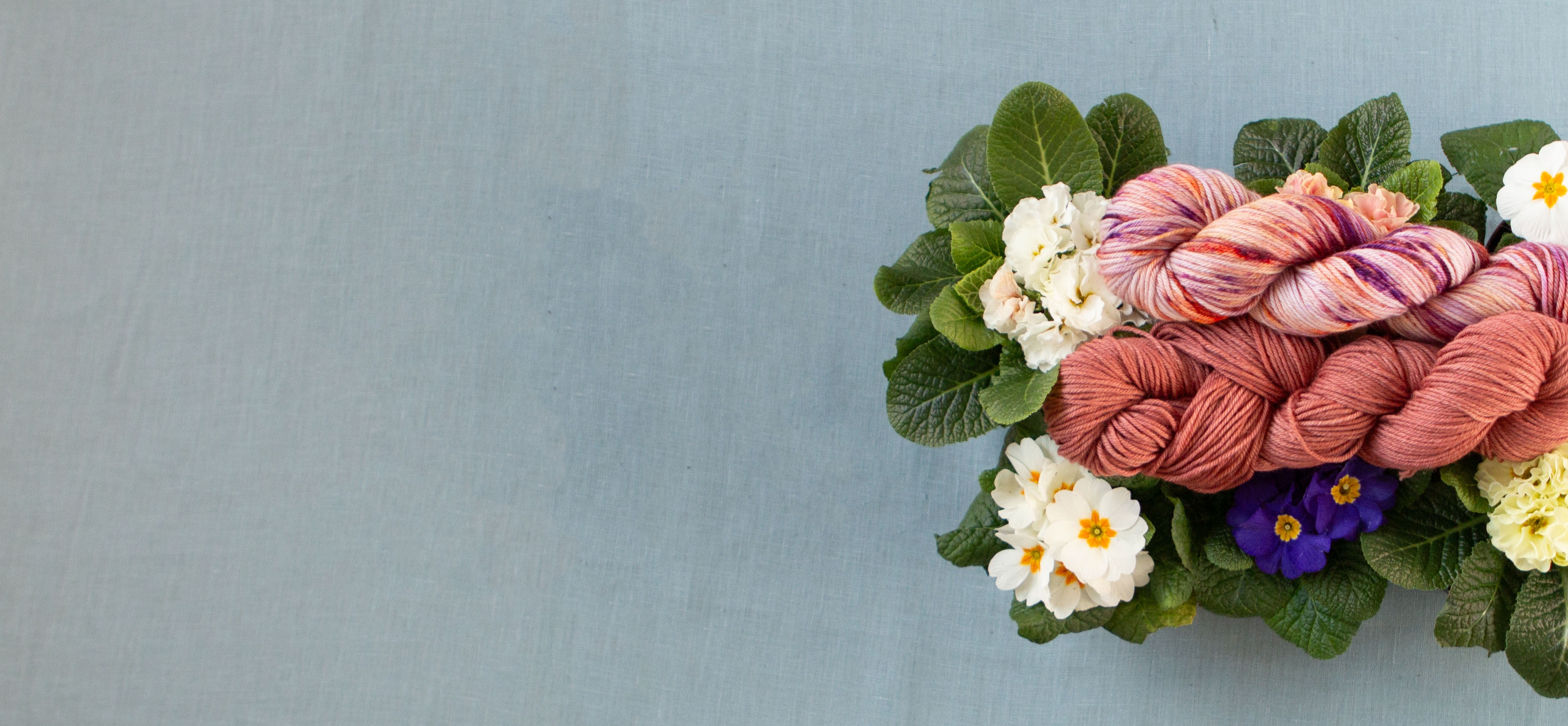 Spring Seasons yarn laid out on spring flowers.