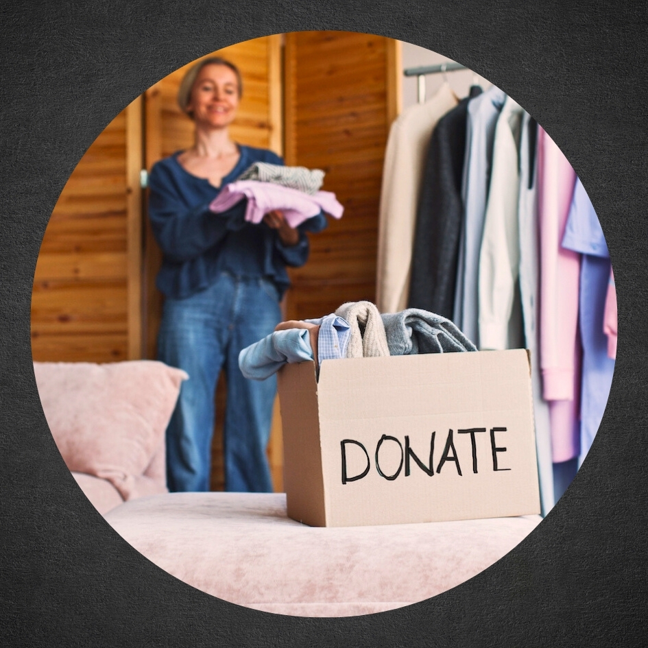 woman carrying folded clothes over to Donation box  on bed