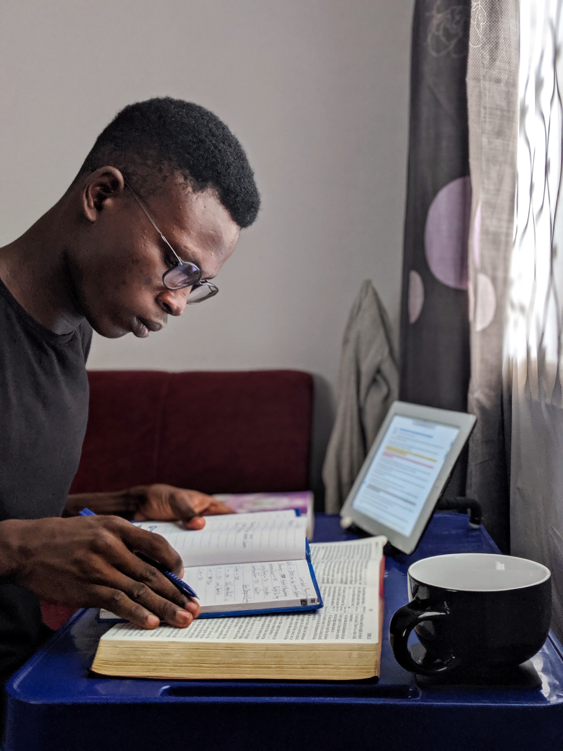 person studying with computer and bible