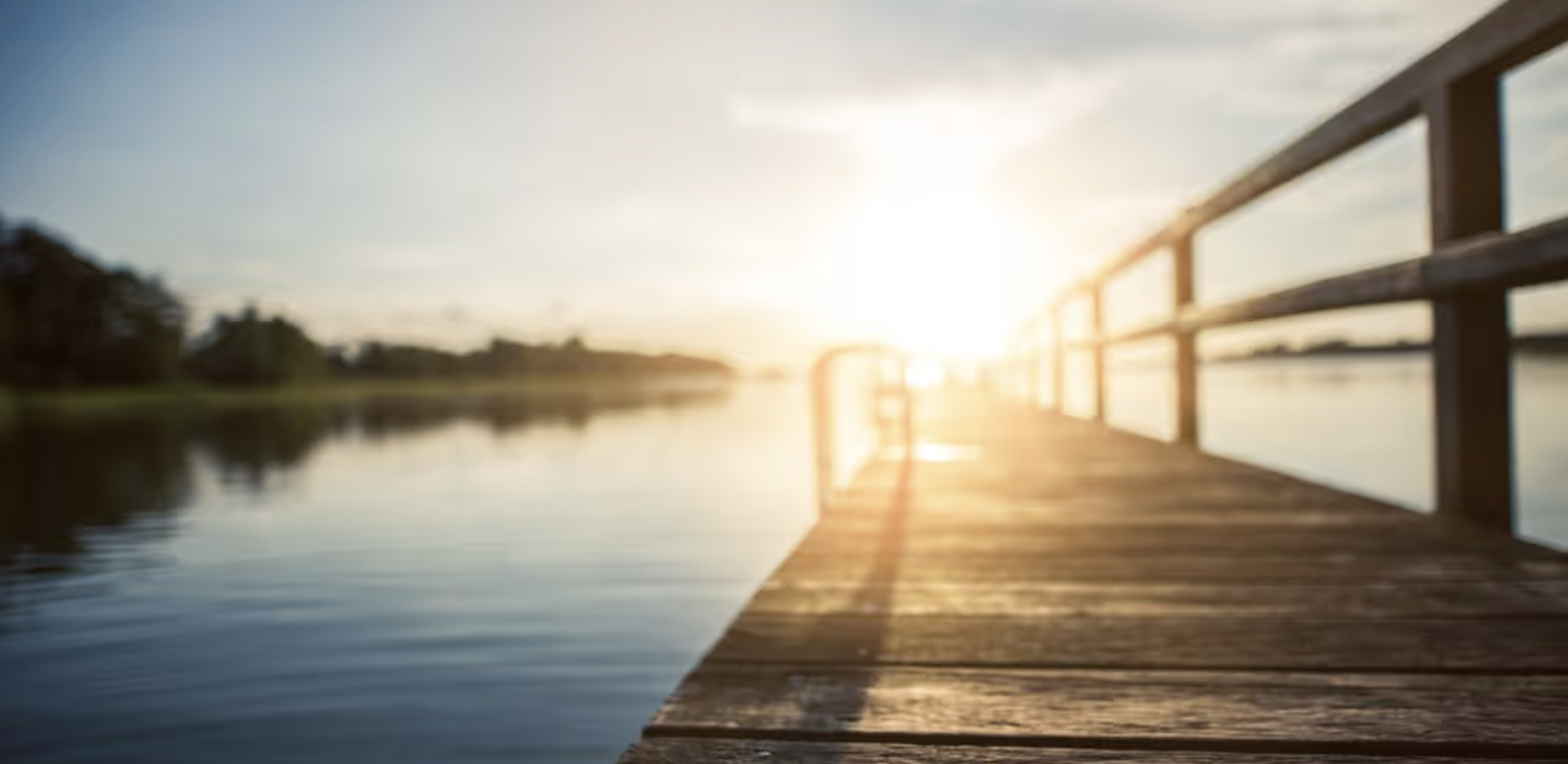 Wooden Pier extending into lake during sunrise