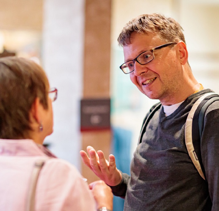 a middle-aged man in conversation with a woman