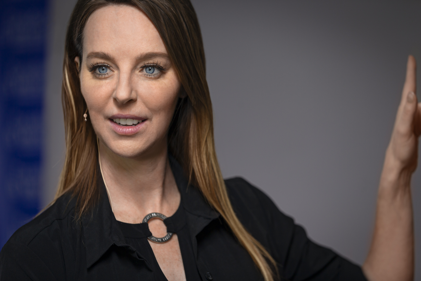 Amber Cameron, founder of Canadian Laser Institute,wearing a microphone, presenting and pointing to screen