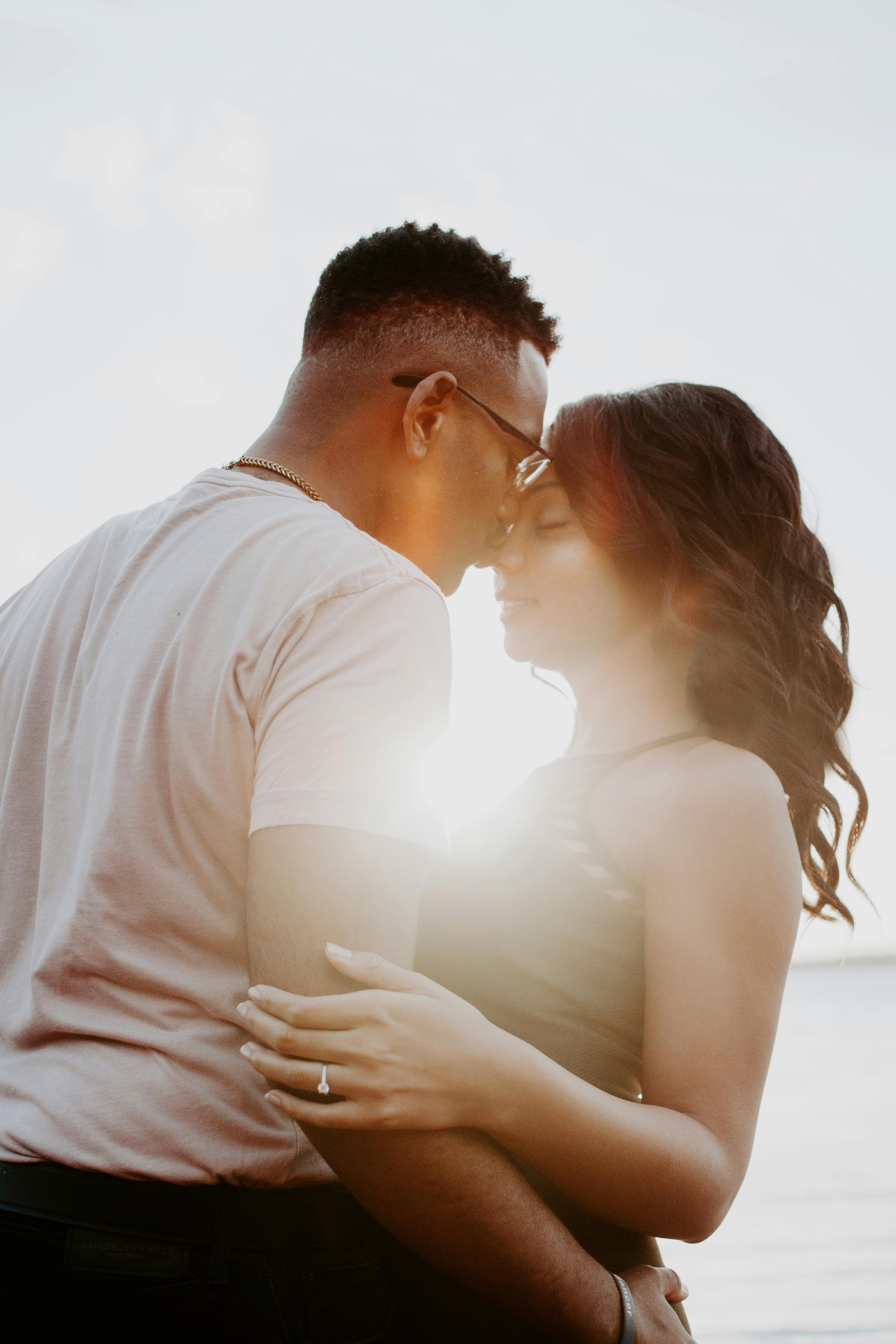 brown skinned couple hugging in the sunlight