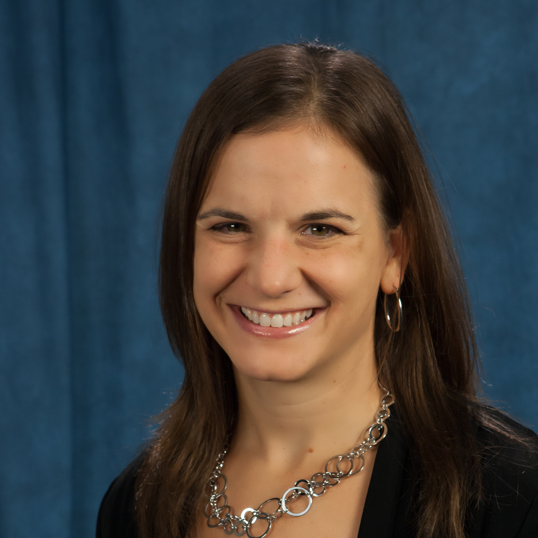 Tanya Campen in a black shirt in front of a blue backdrop