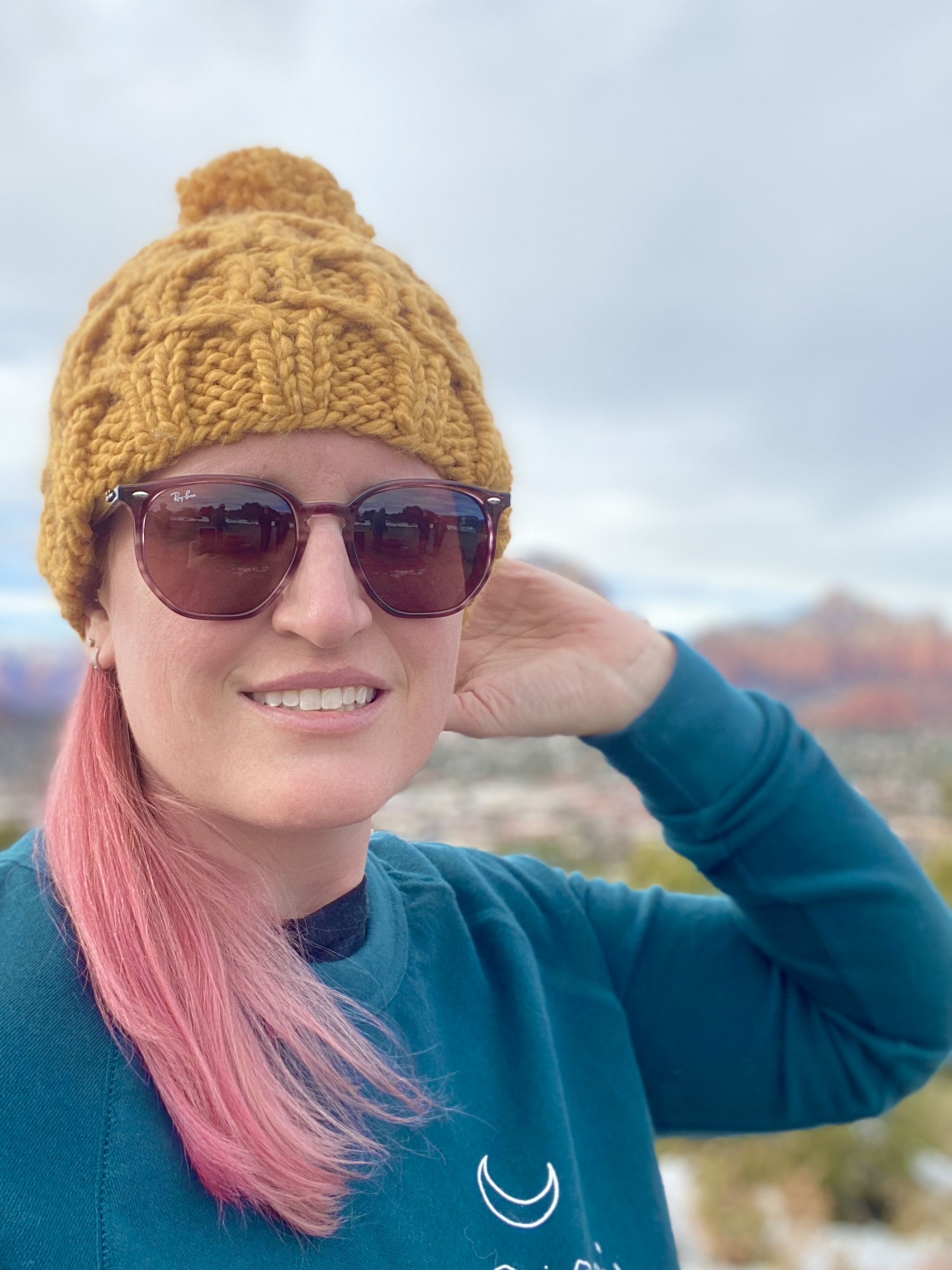 girl wearing bulky cabled hat with pom and sunglasses