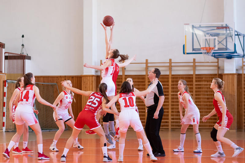 woman&#39;s basketball game, athletes jumping to get a ball.