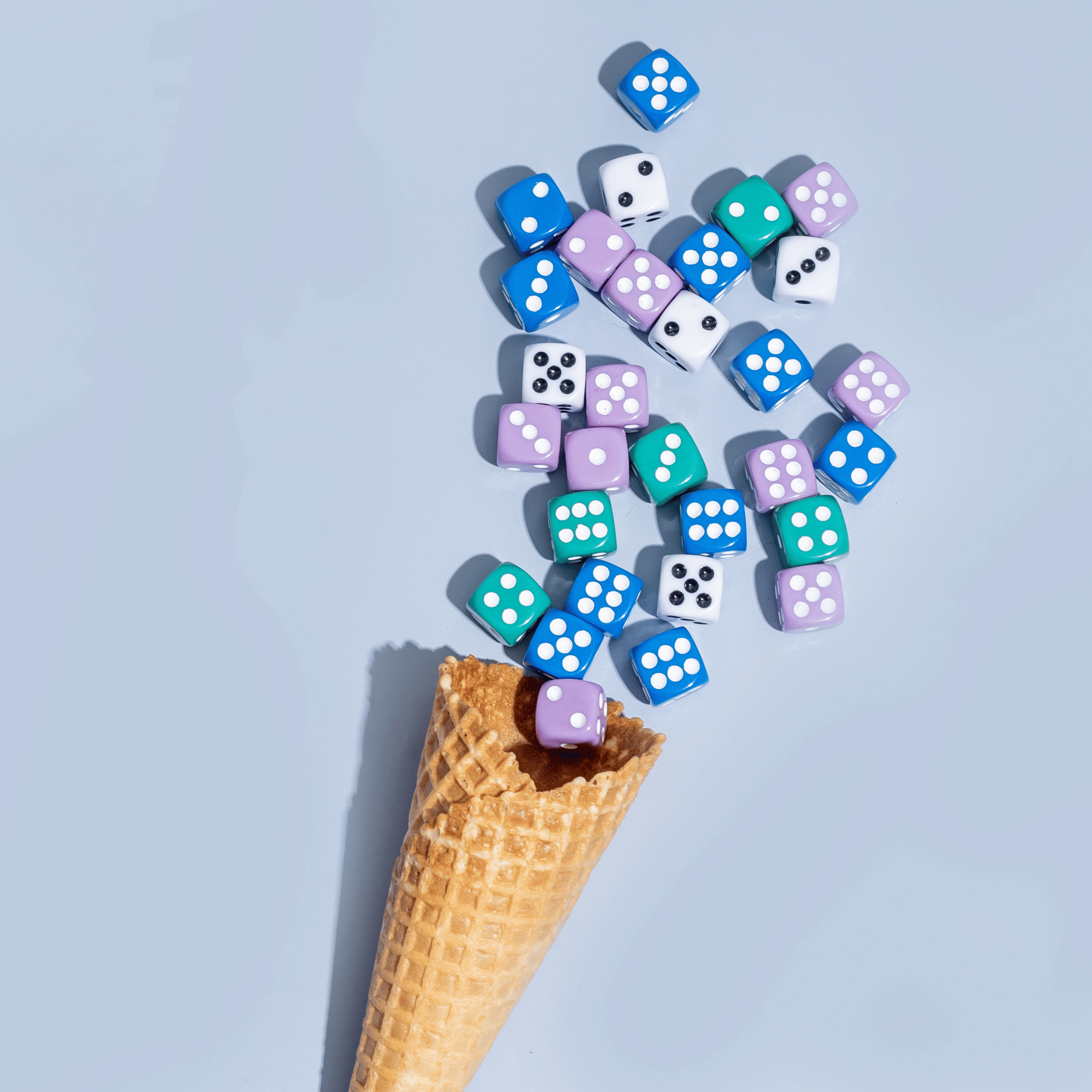 ice cream cone with colorful dice coming out in shape of ice cream