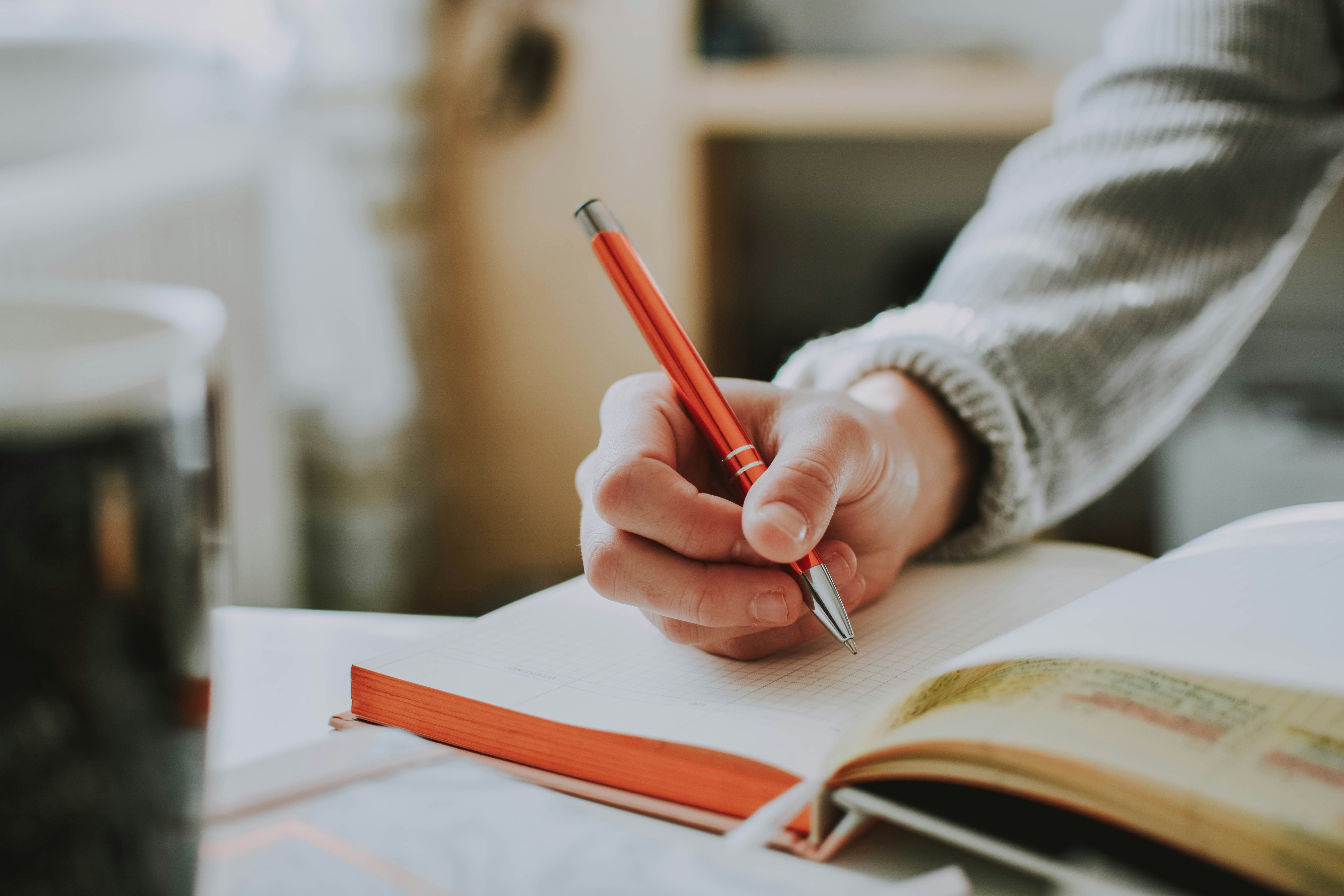 Man's hand writing in a notebook