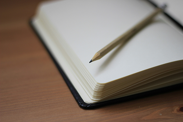 A young woman writing in a notebook