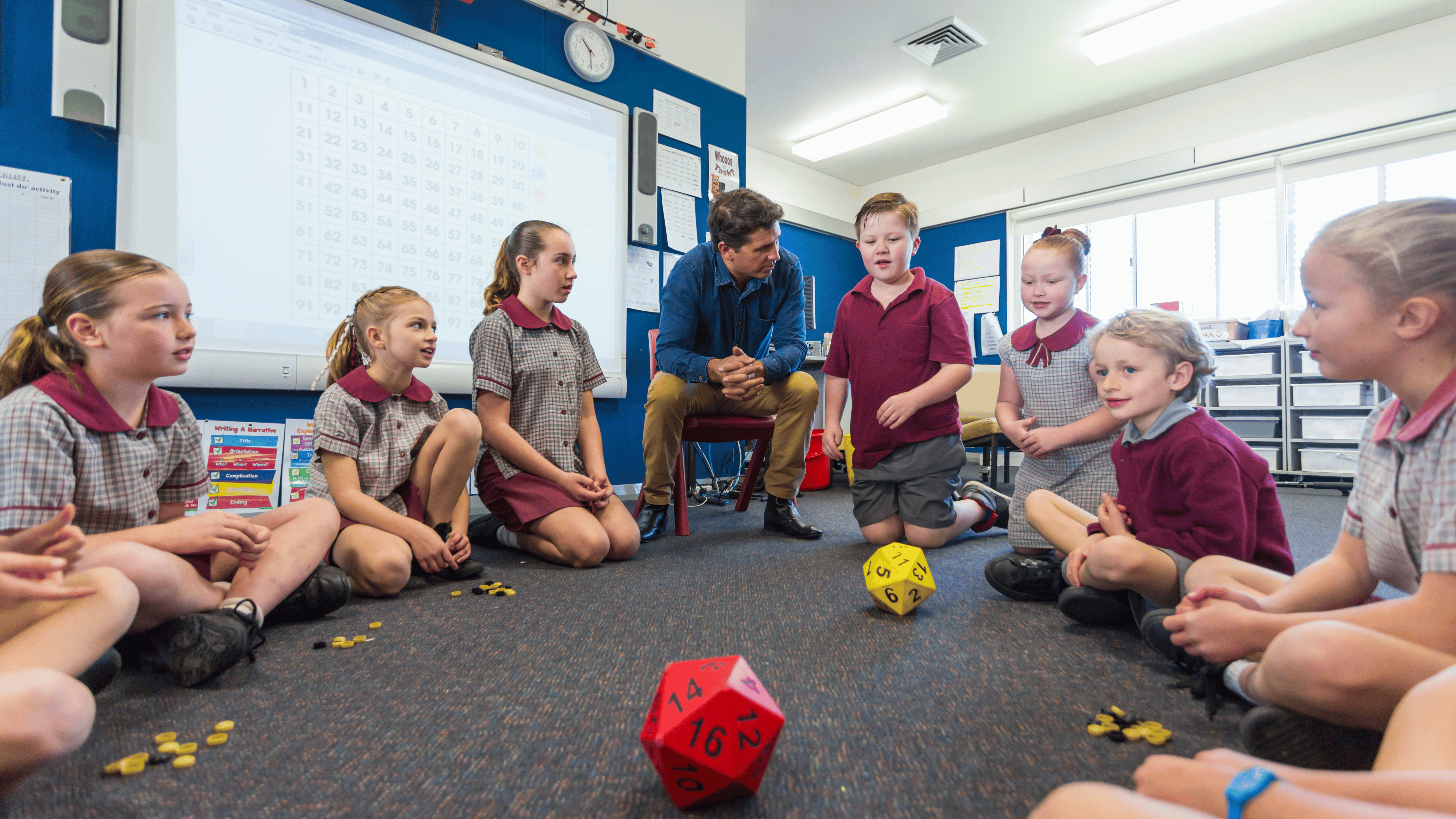 students sitting in circle with teacher talking about math