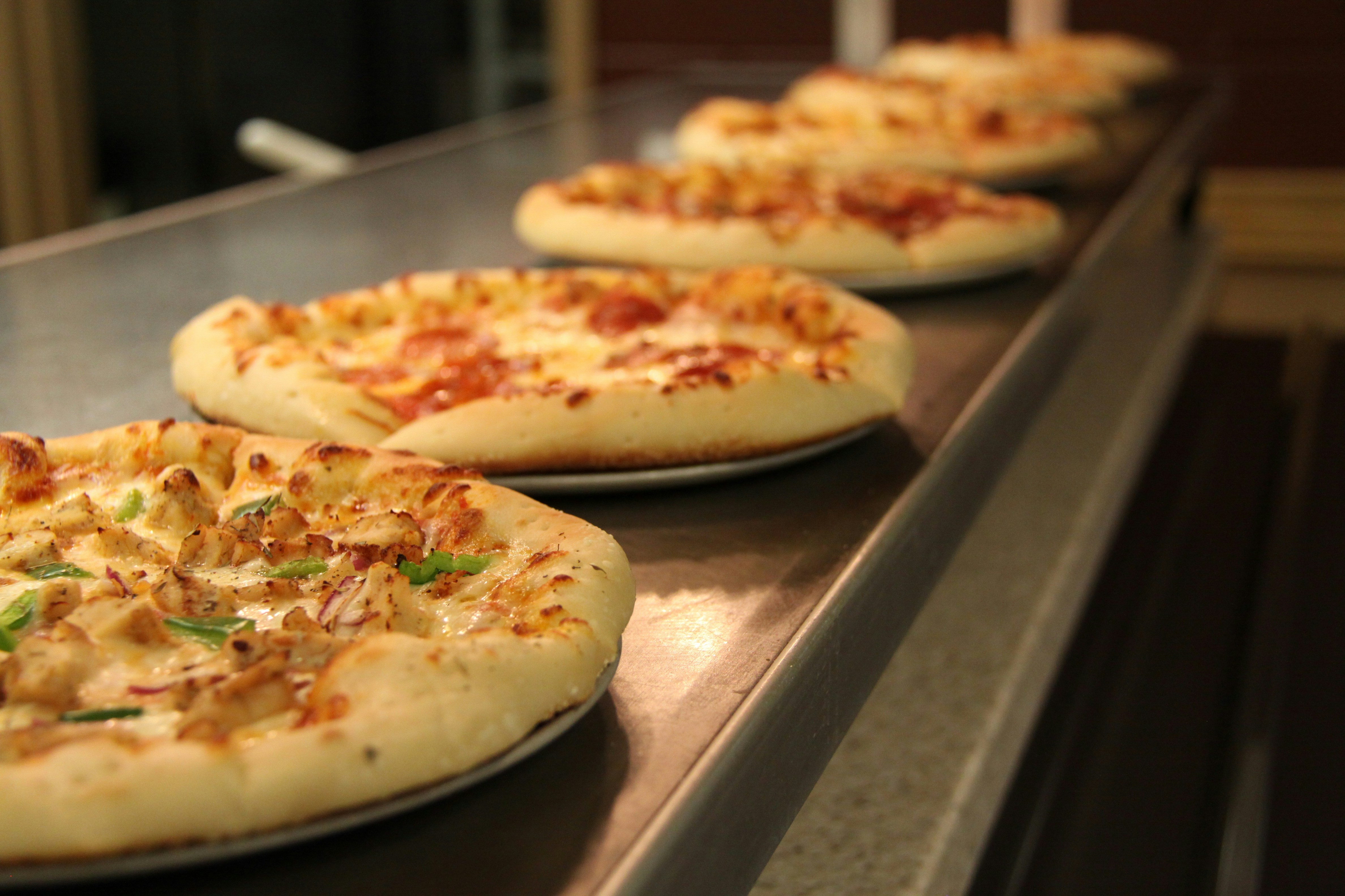 Pizzas in a line on a buffet