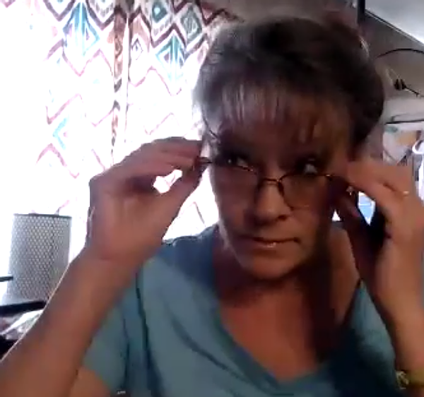 Photo Of Bobbi Lynn Gibson with glasses, blue shirt, sitting at desk. 