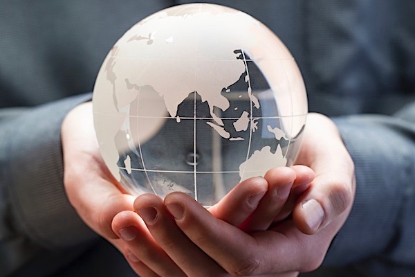Man&#39;s hands cupped together cradling a small globe