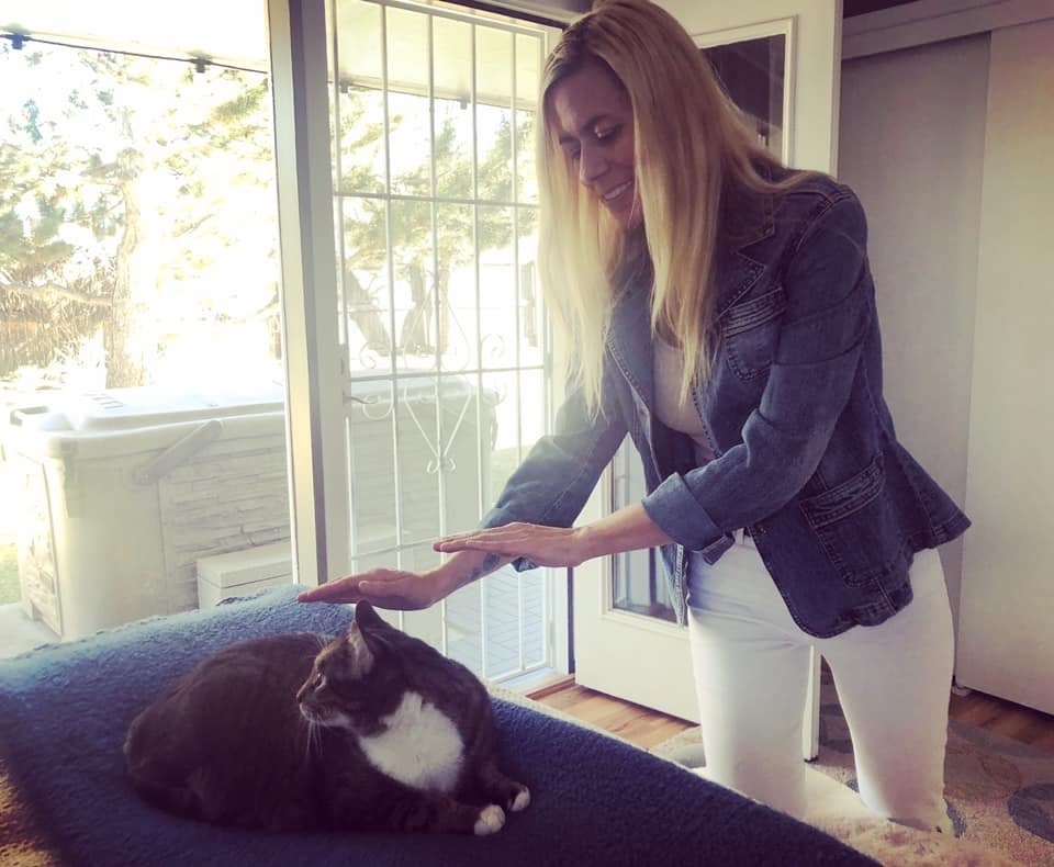woman doing Reiki on a cat
