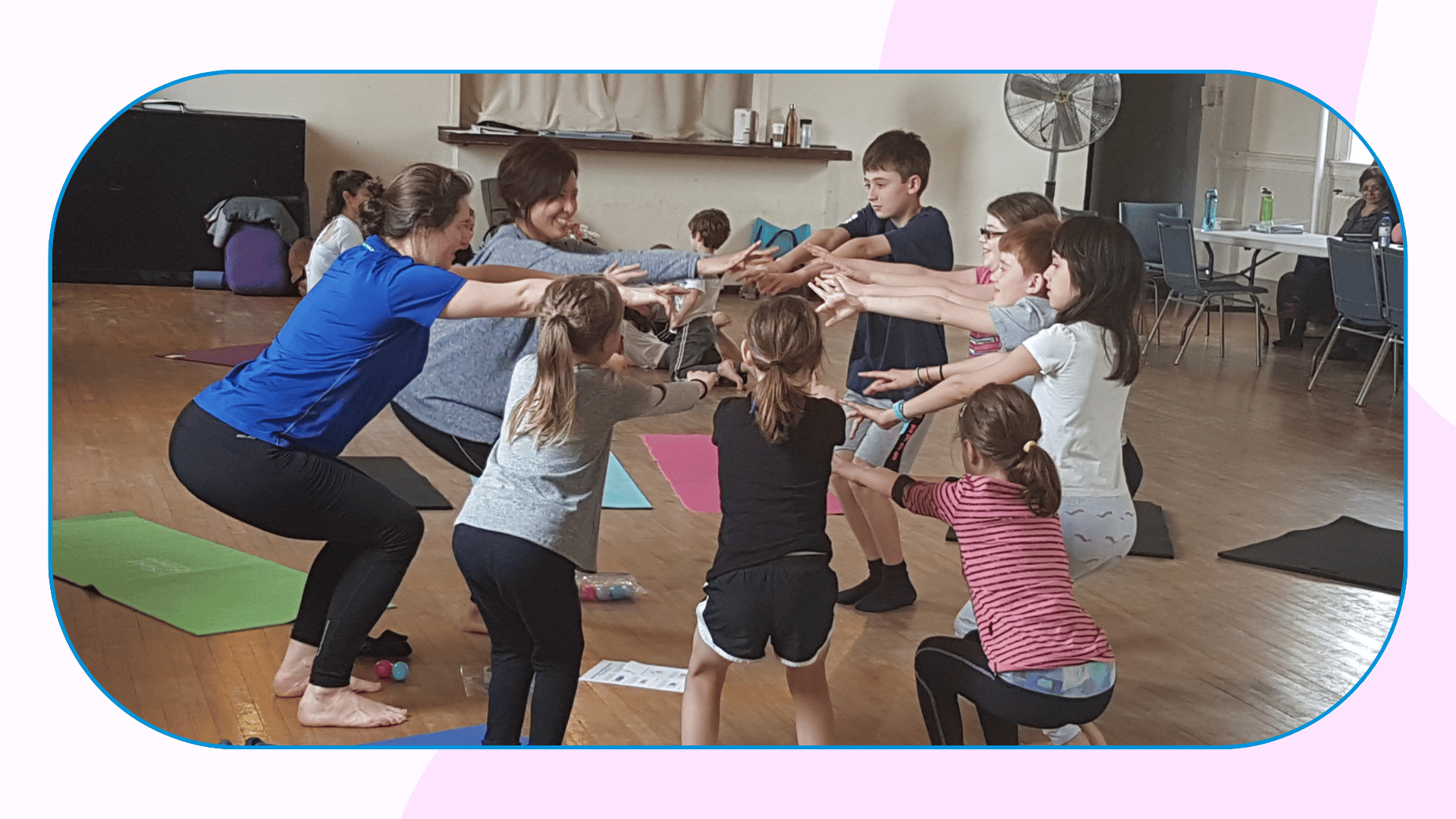 A group of 7 children and two adult stand in a tight circle doing chair pose.