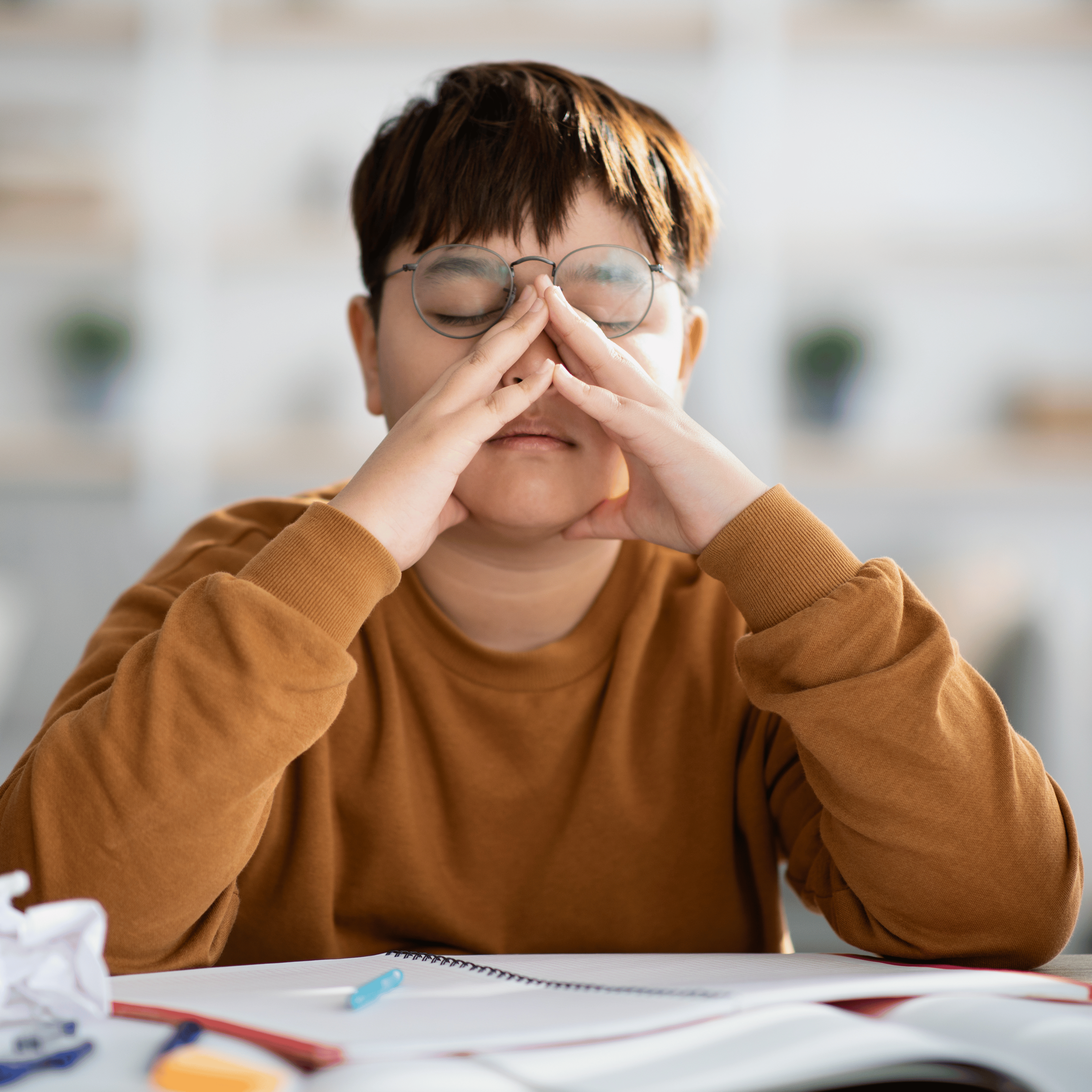 student upset with eyes closed and hands on face