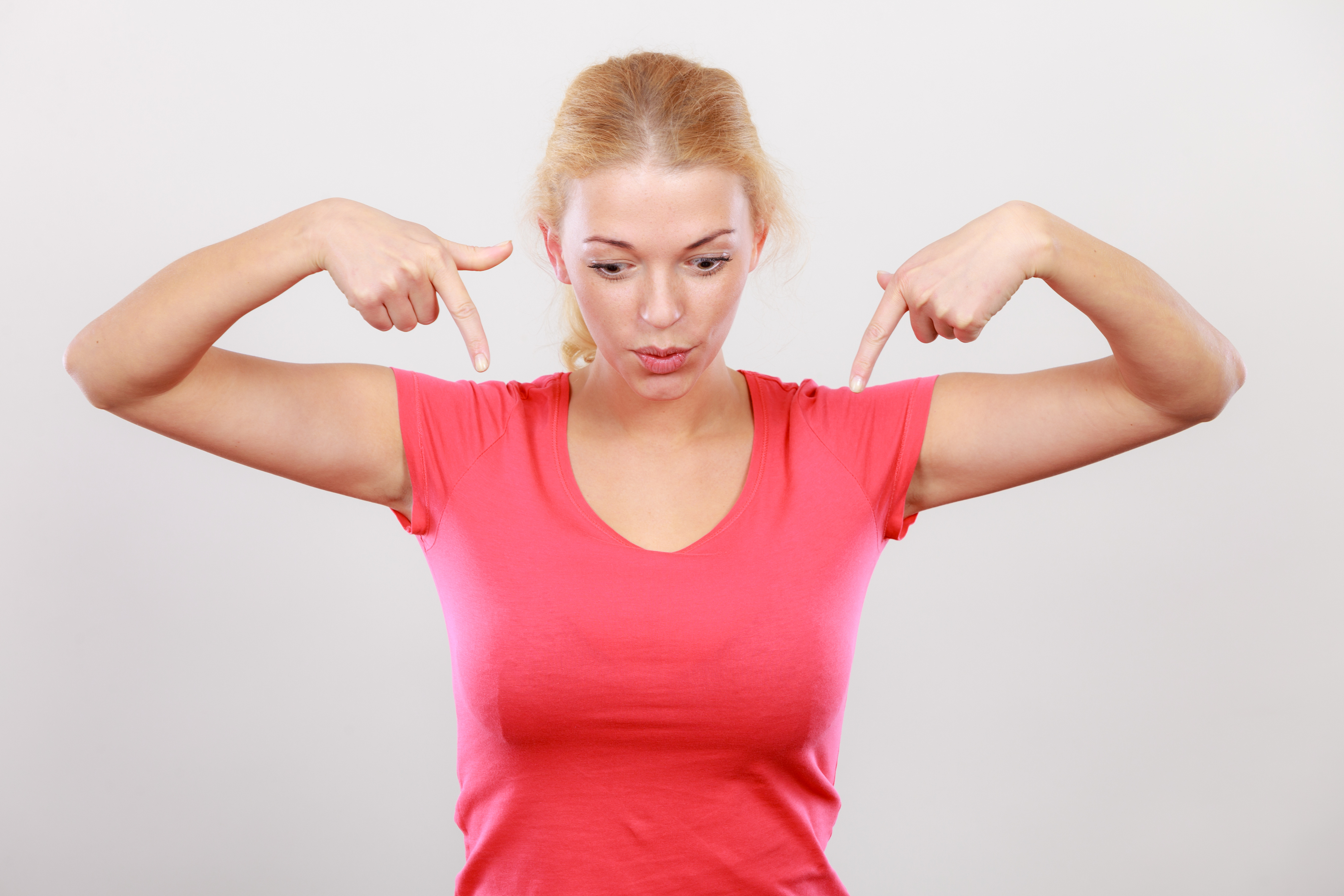 Woman in pink shirt pointing down to the words Coaching with Kate Hall