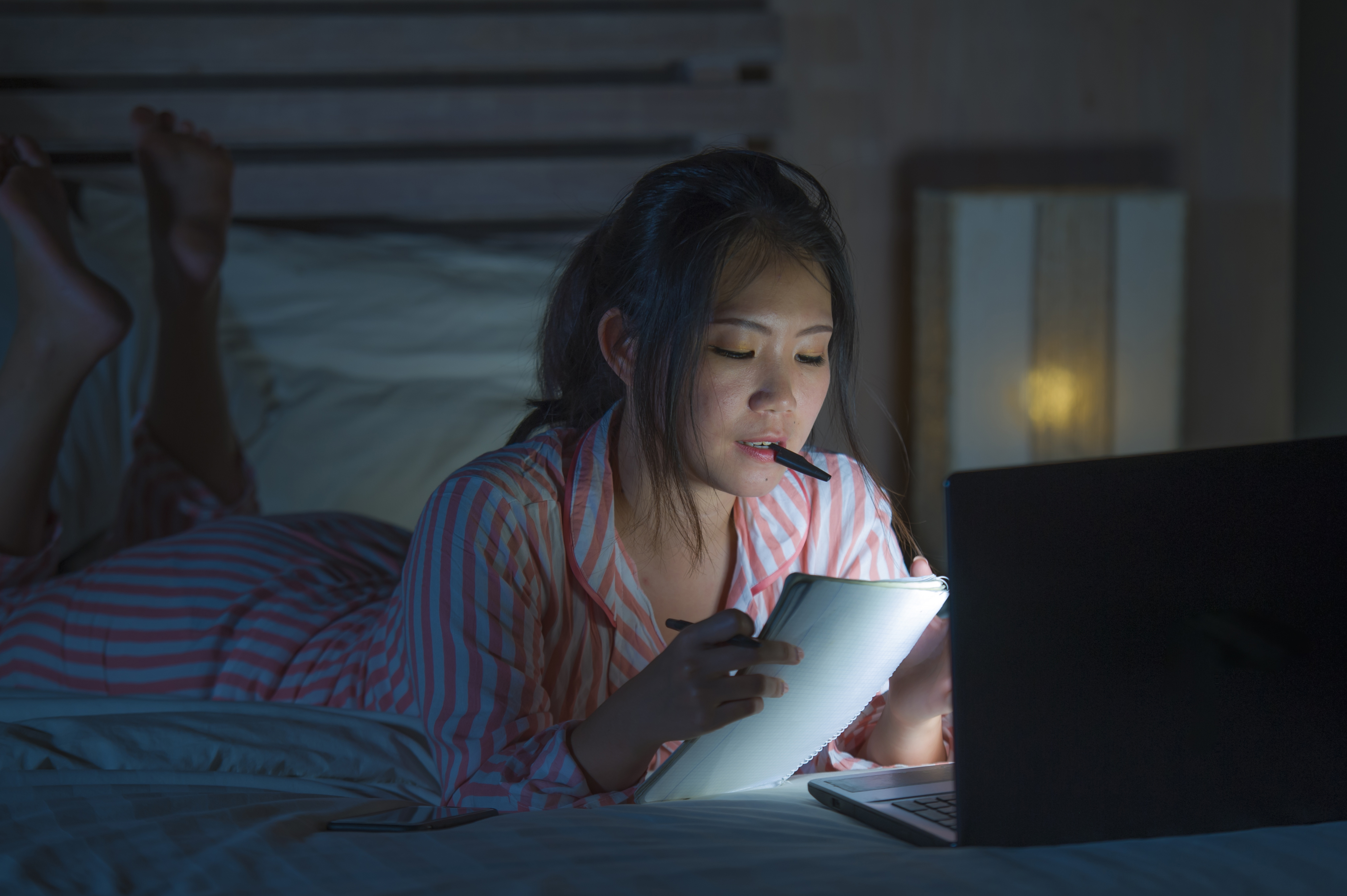 girl writing on bed