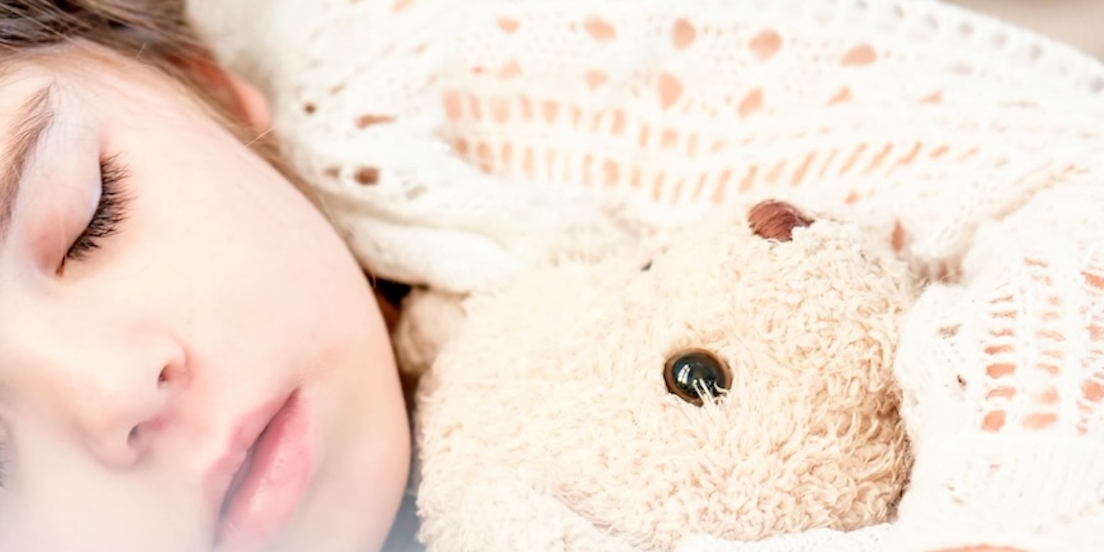child sleeping with teddy bear