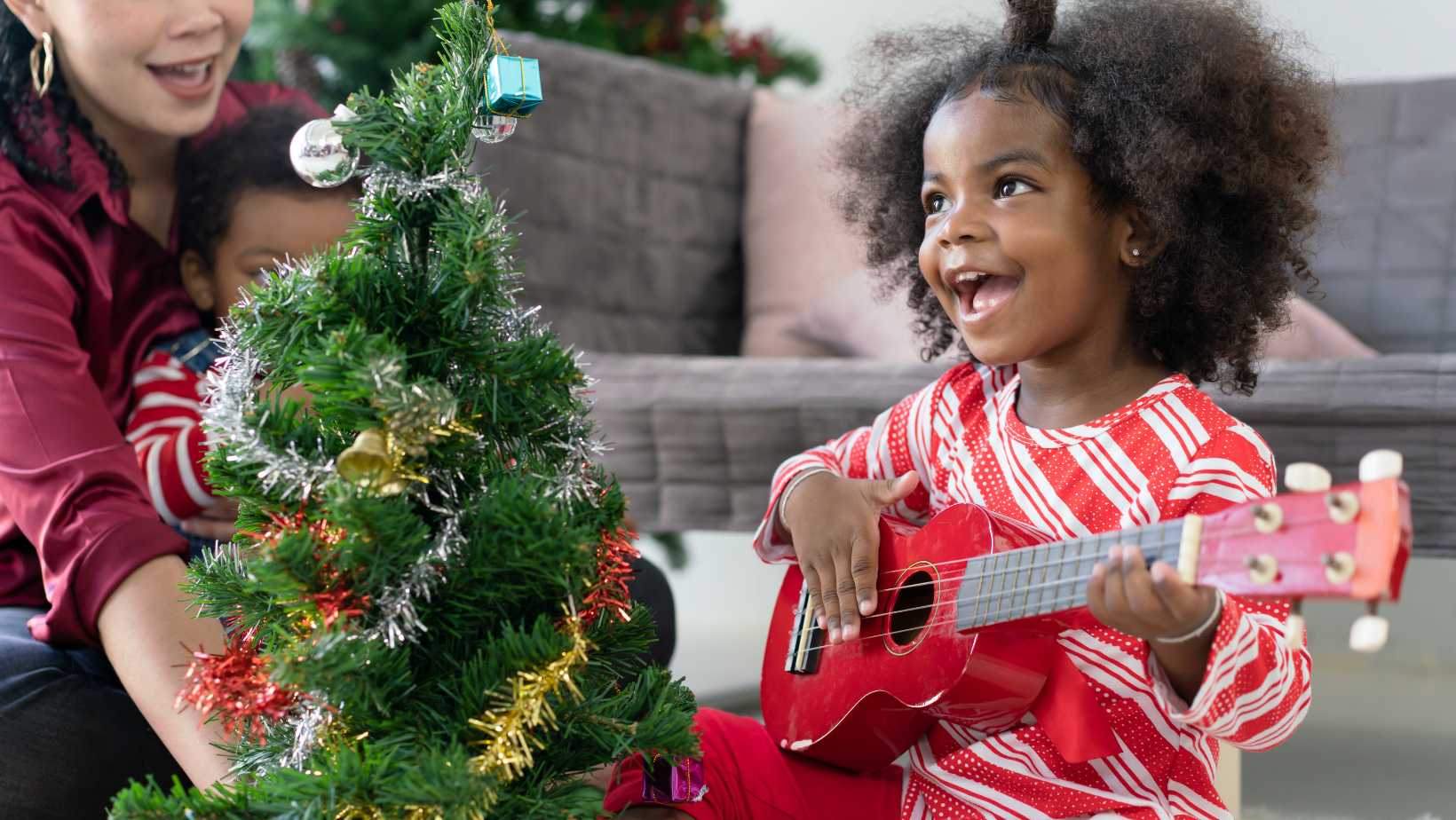 cute girl with red ukulele and christmas tree