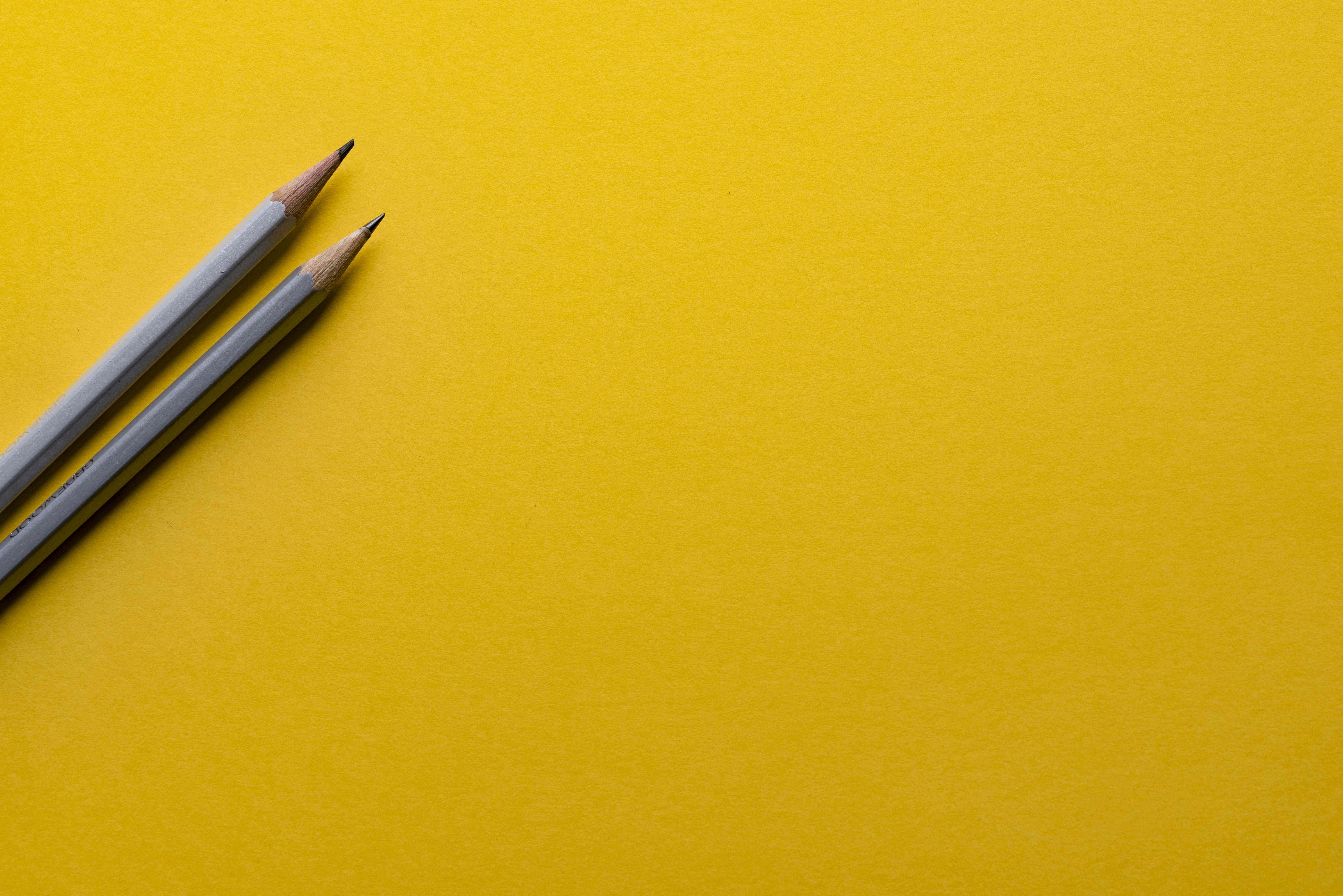 Picture of 2 pencils on yellow background