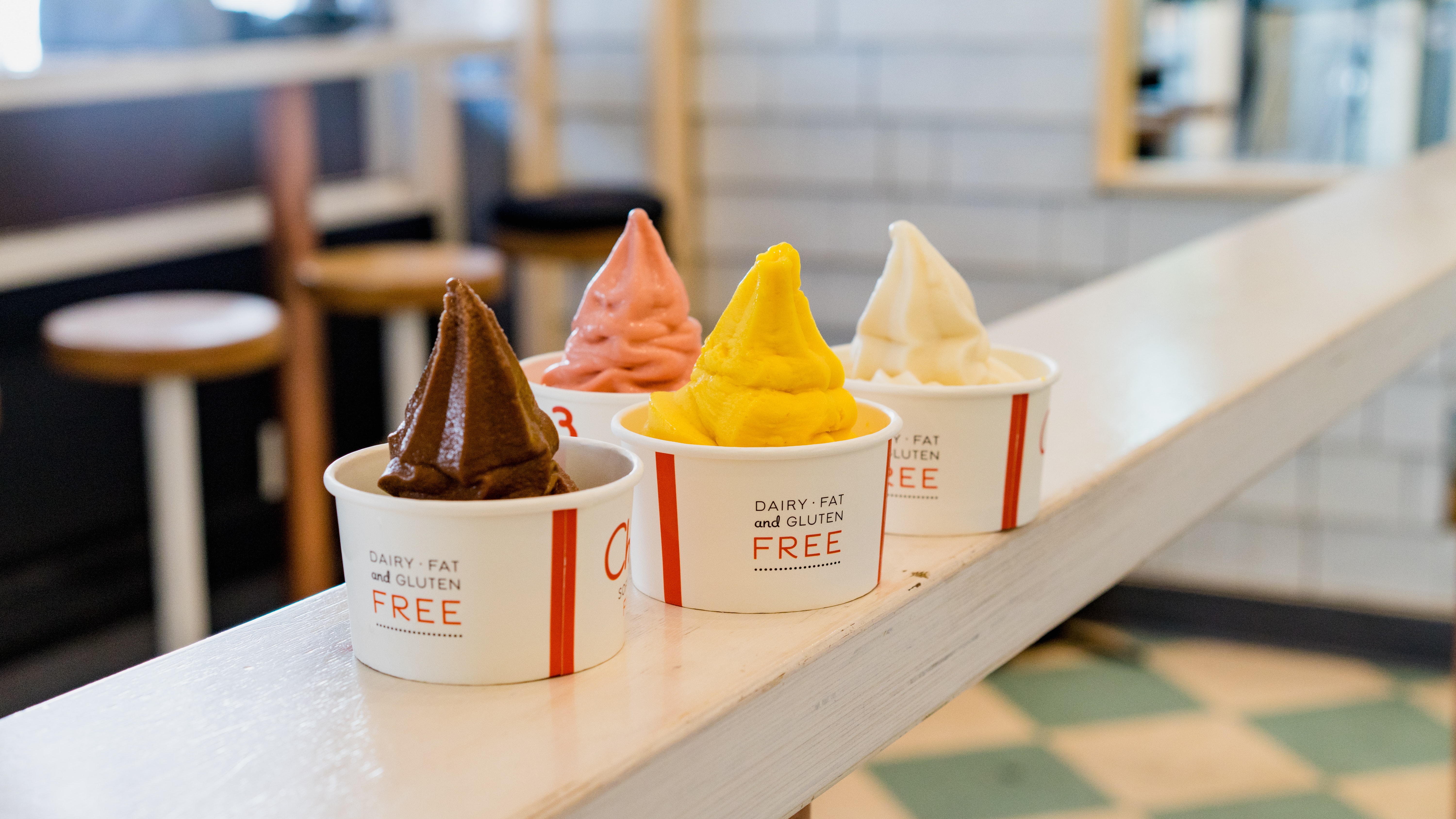 Four containers of different colored frozen yogurt