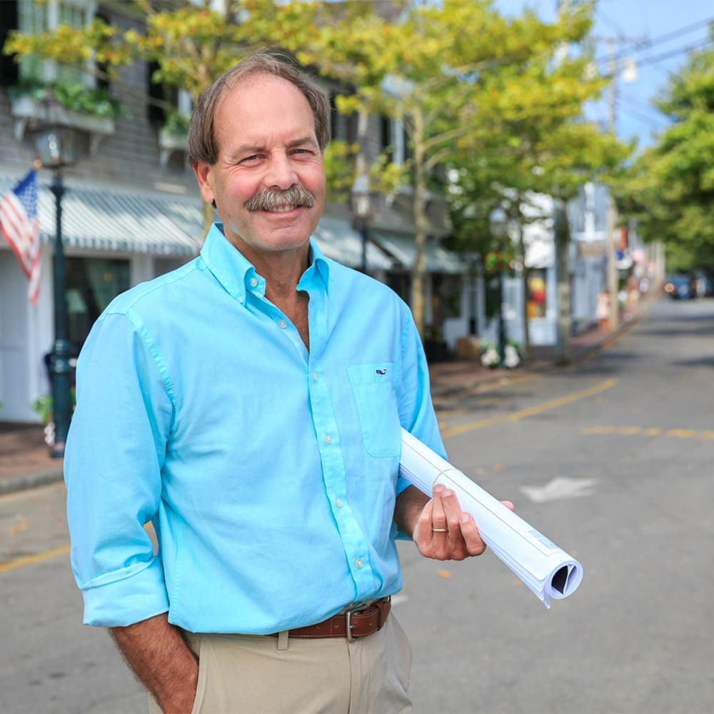 Image of Patrick standing in the street with architectural drawings