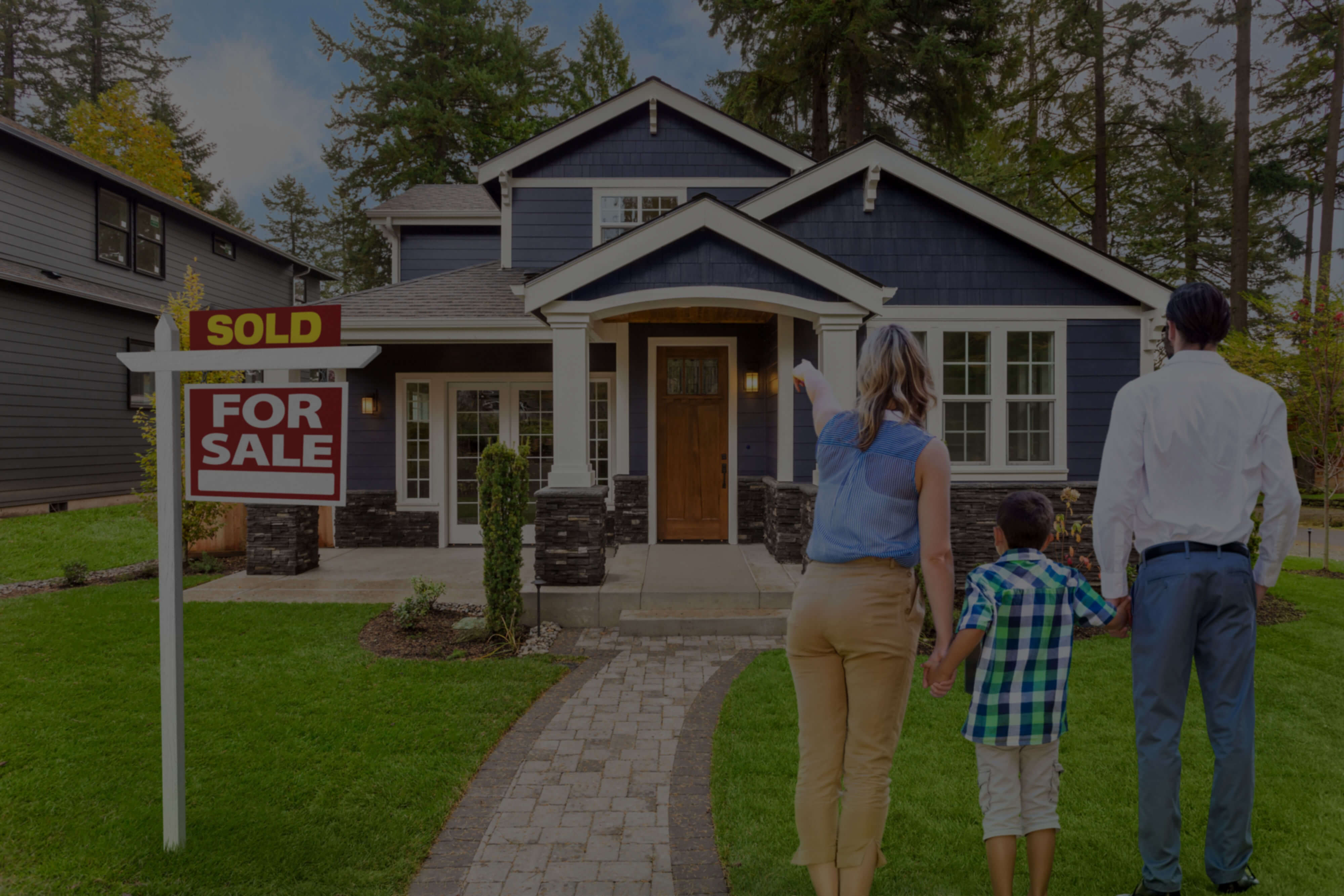 Family in front of home with sold sign