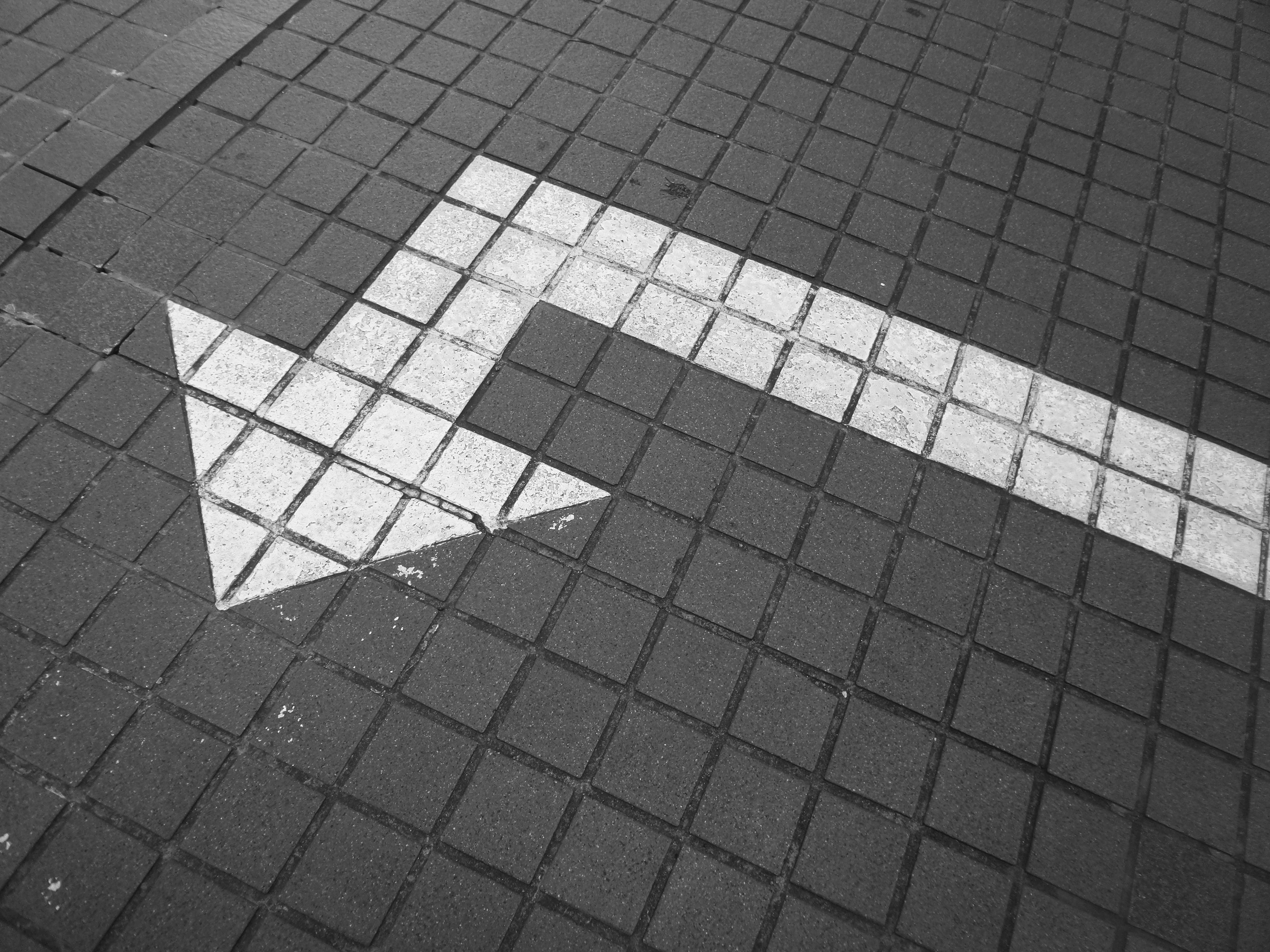 Arrow on sidewalk turning at right angle