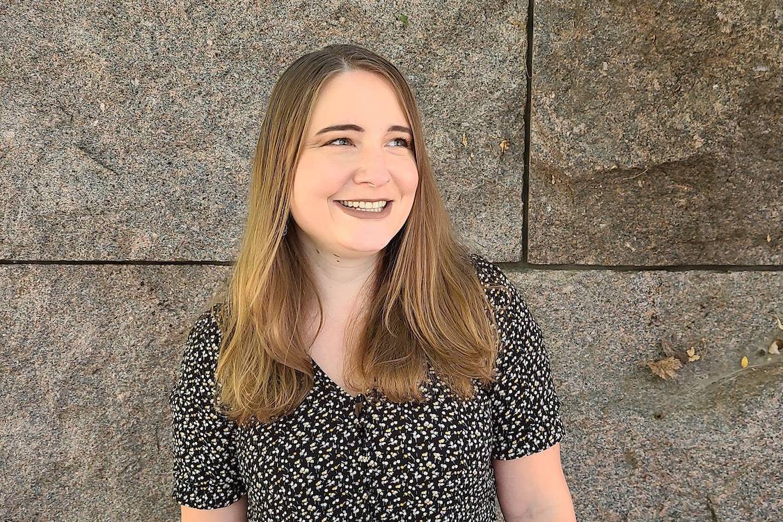 woman smiling in front of a grey wall