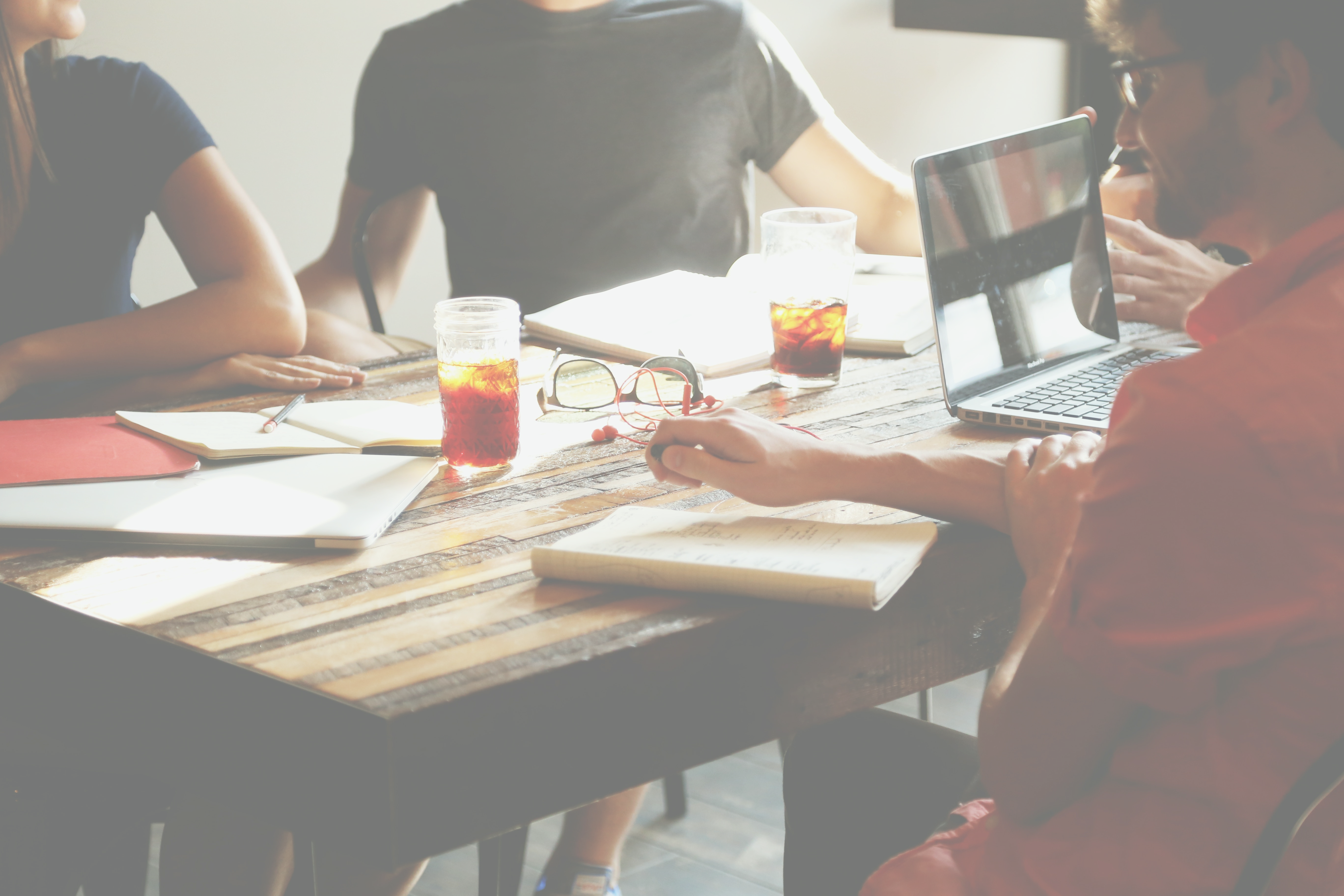 Background image of people gathered around a table at a coffee shop