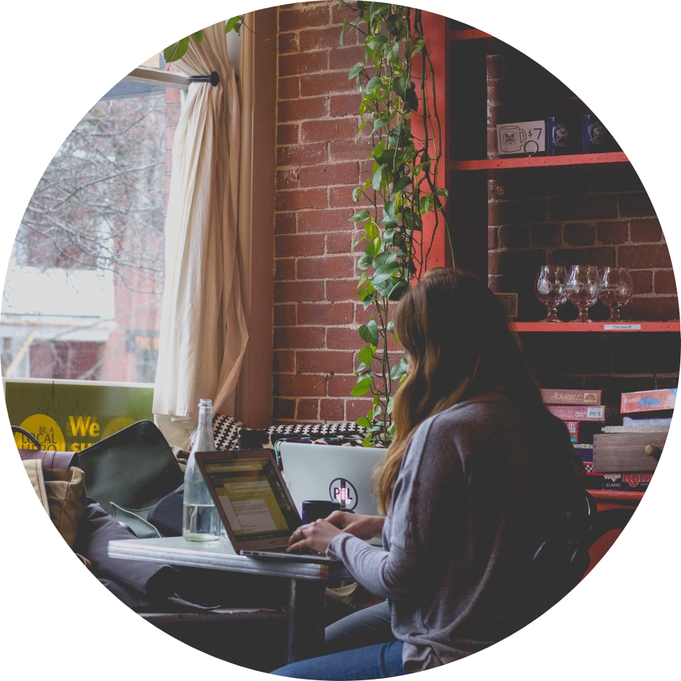 Mujer estudiando en un café con una computadora portátil