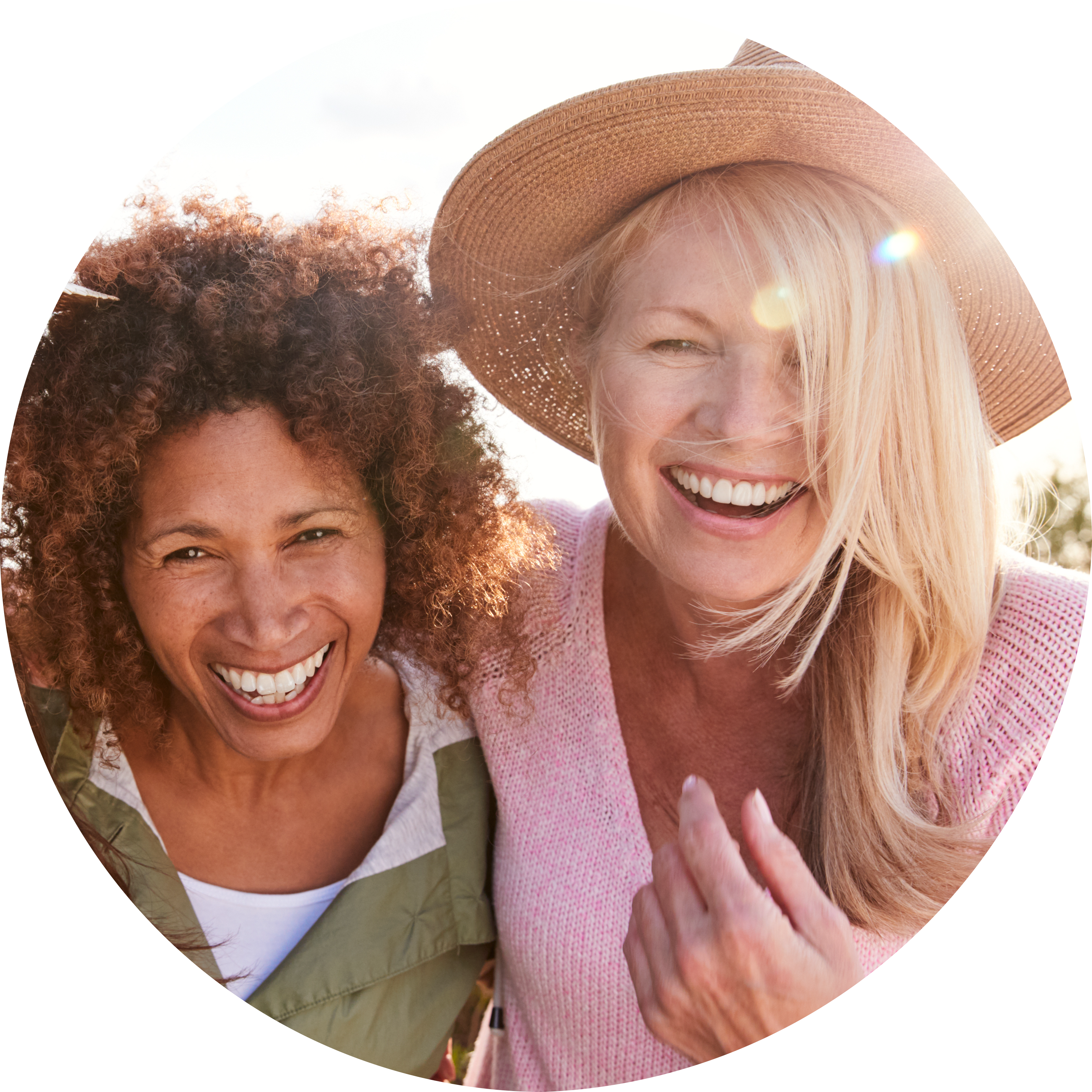 Midlife women laughing together in sunshine 