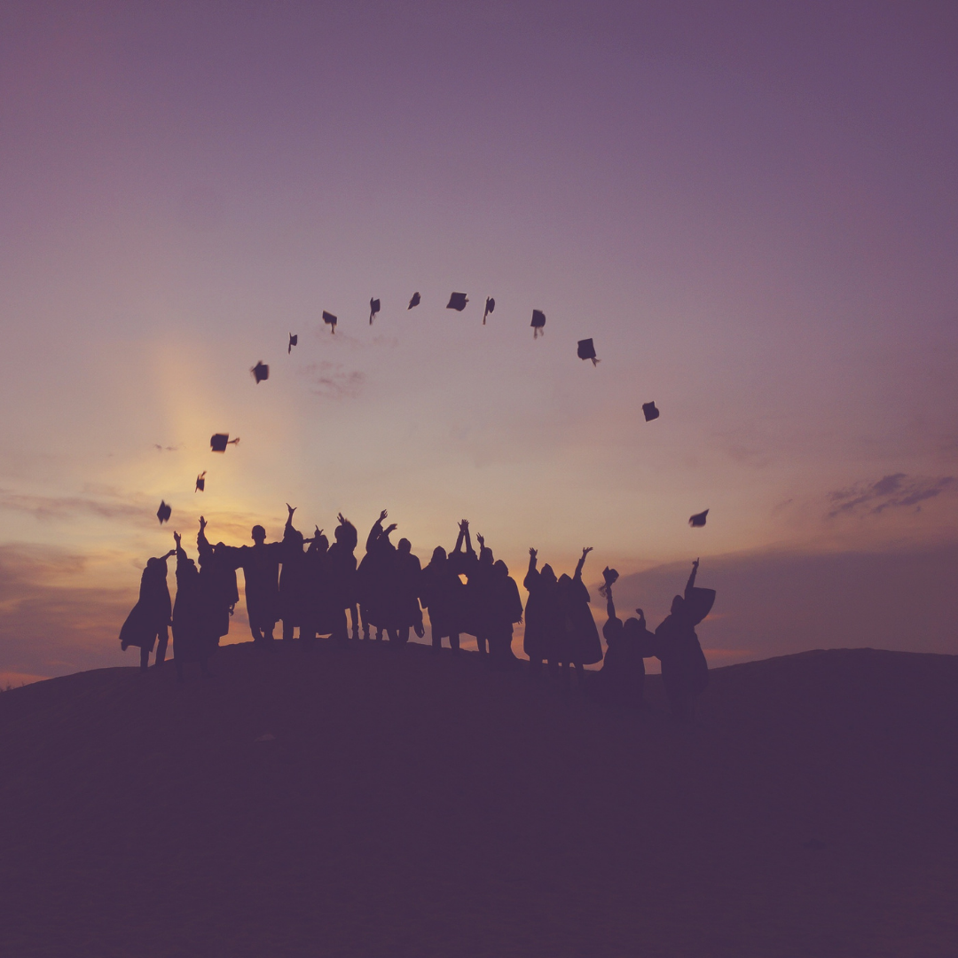Des finissants lançant leur chapeau de graduation en l'air.