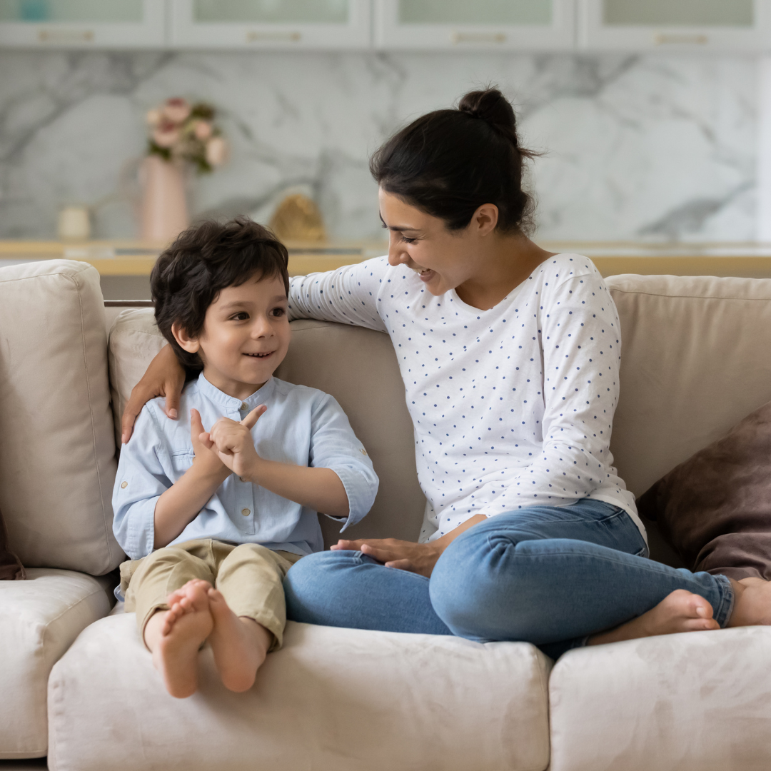 smiling boy on couch with mom 