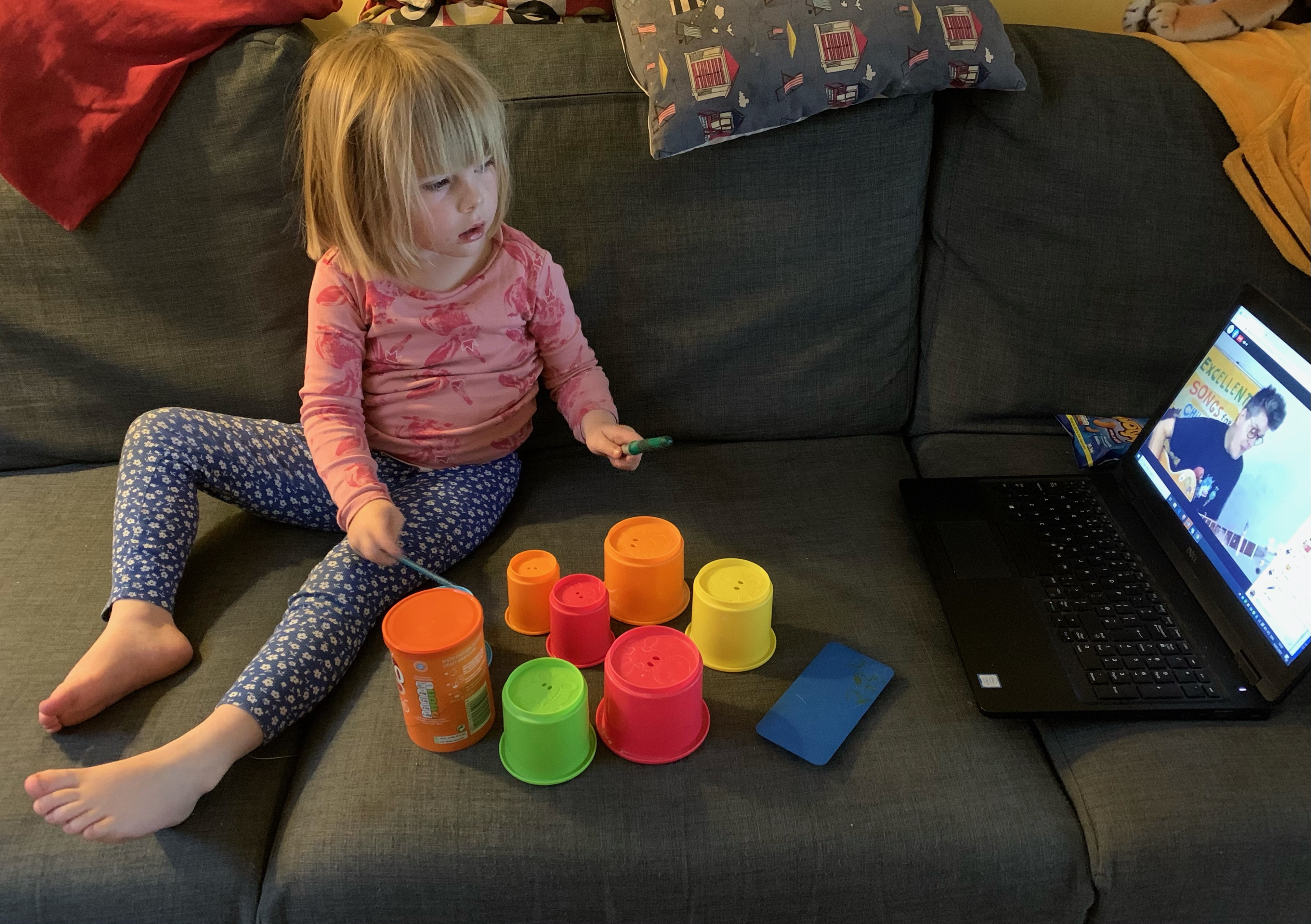 Little girl plays homemade drums to Al Start on laptop