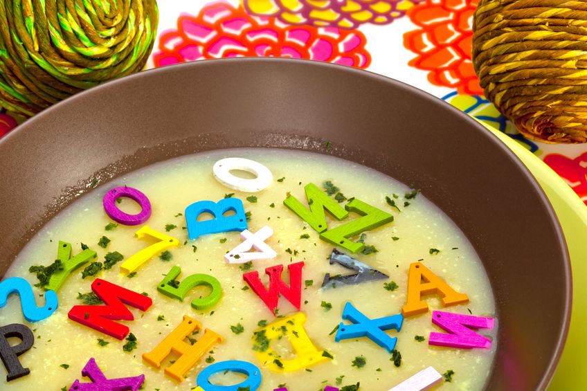 A bowl of light broth with floating magnetic letters