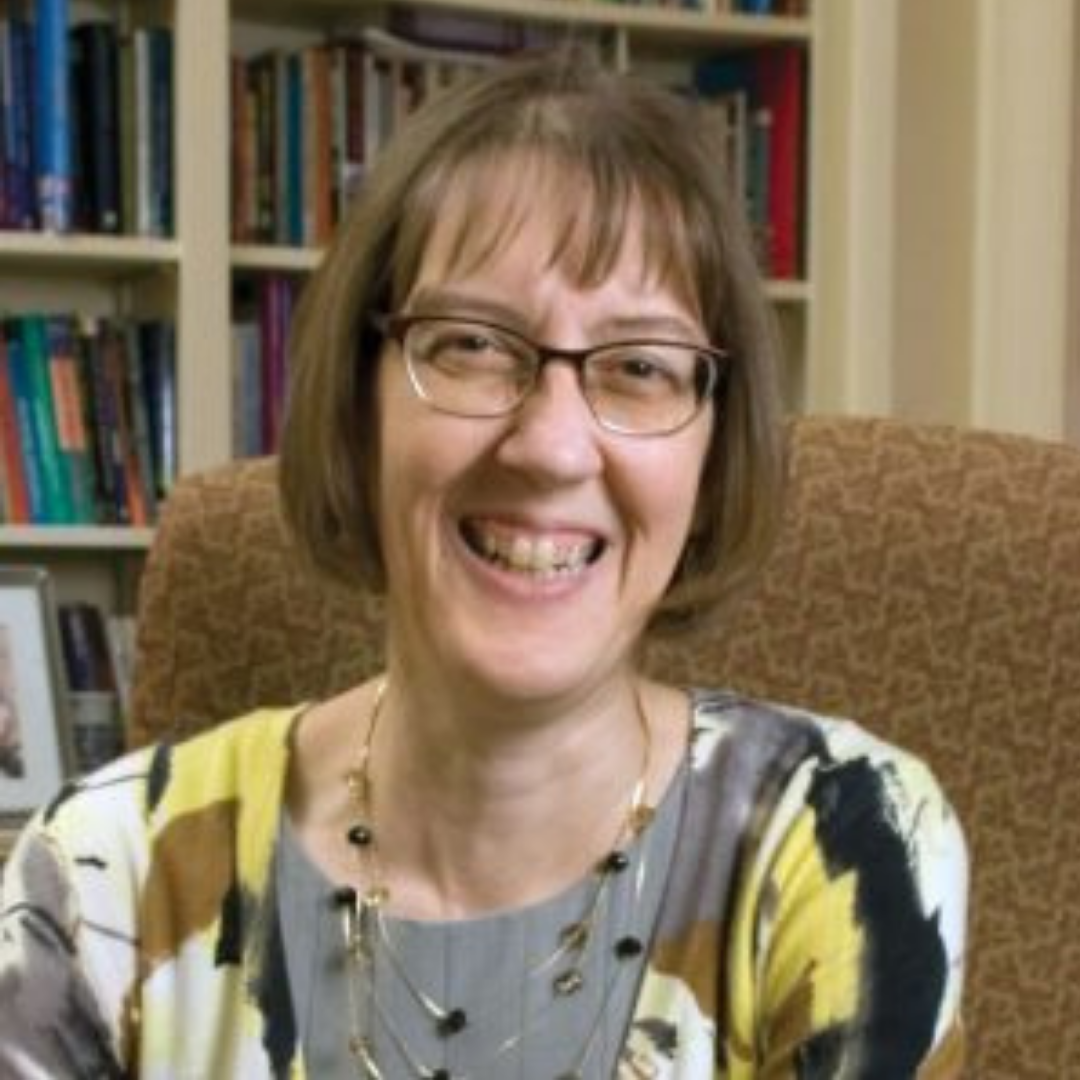 Karen-Marie Yust in a chair in front of a bookshelf