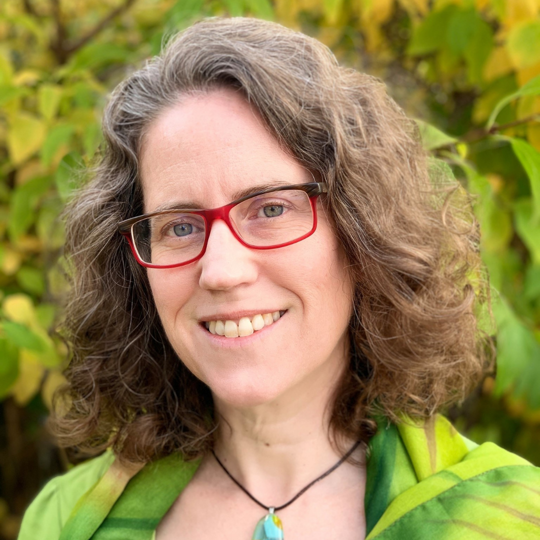 Laura Alary in glasses in front of greenery