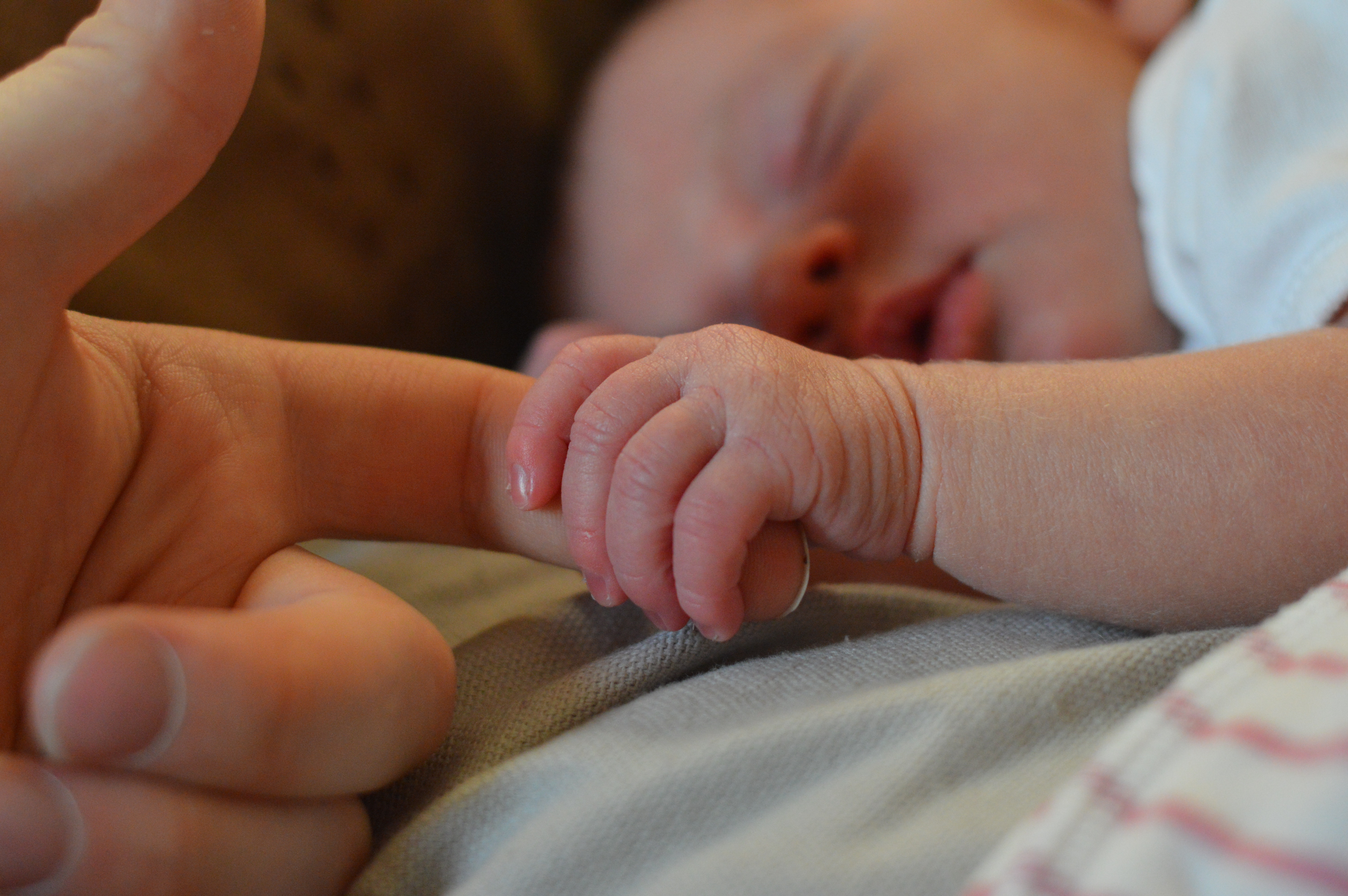 mother and baby holding hands