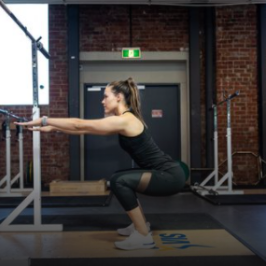 Woman performing squatting exercise to help with ACL recovery
