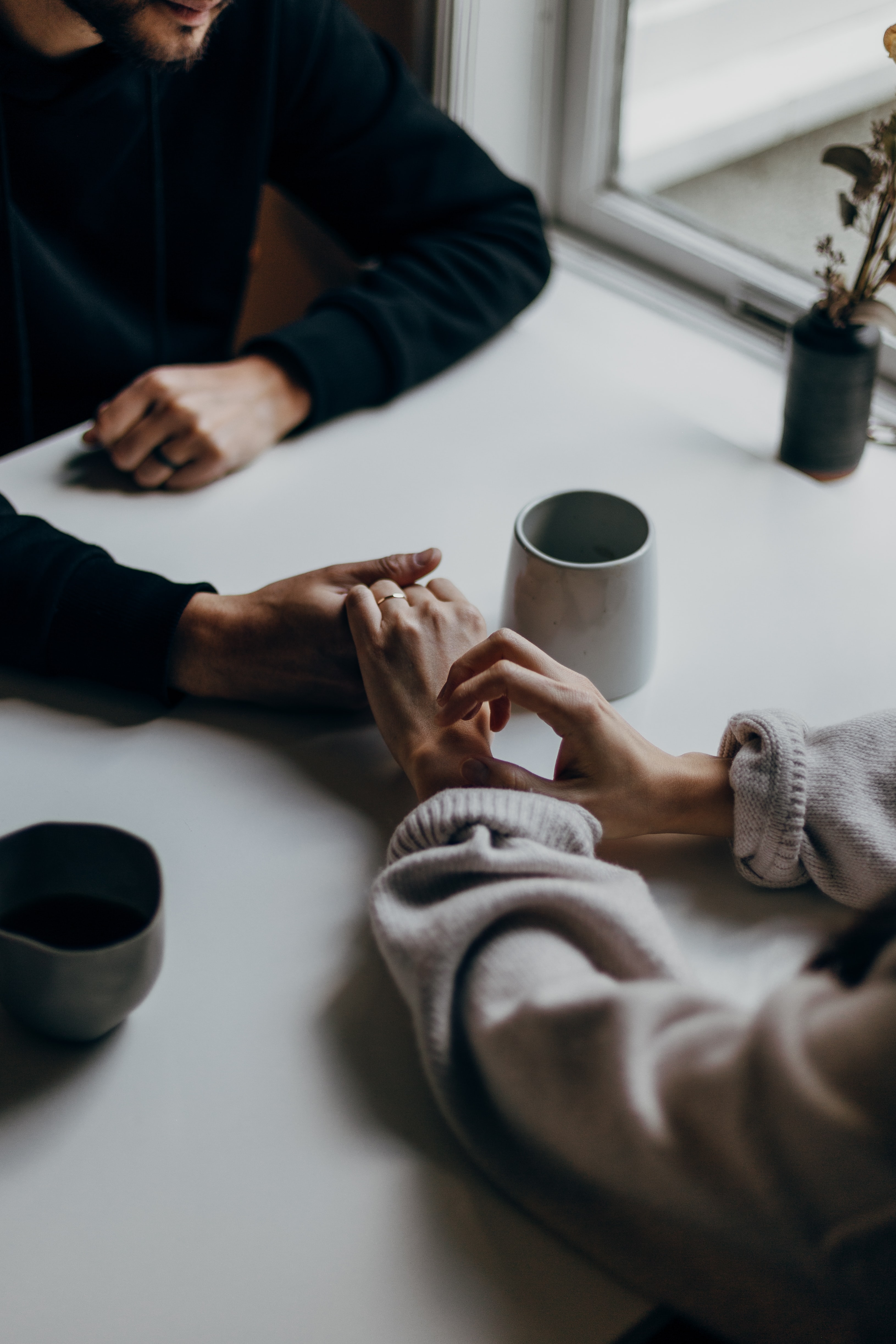 Couple holding hands over a table