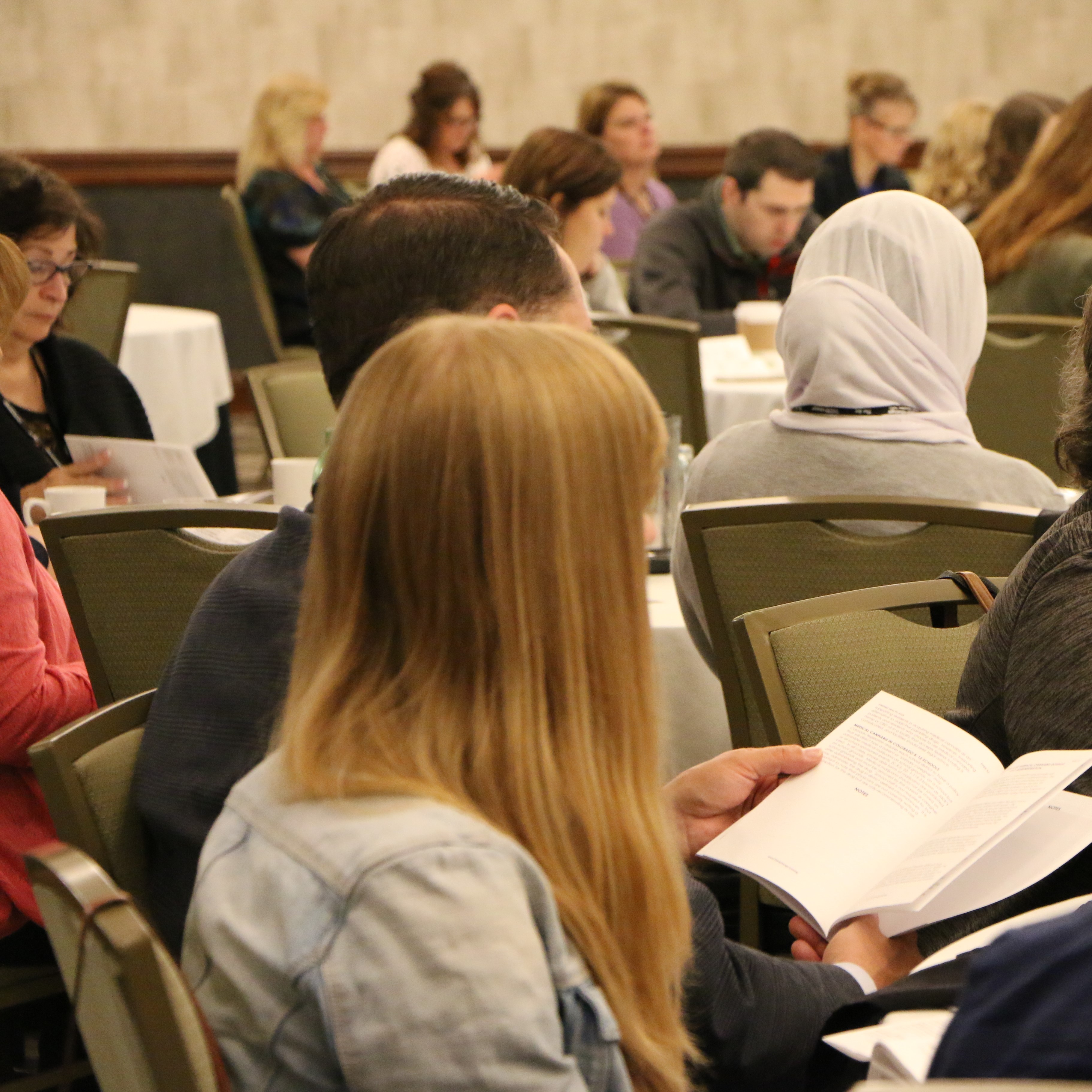 People sitting at a conference reading manuals reading manuals 