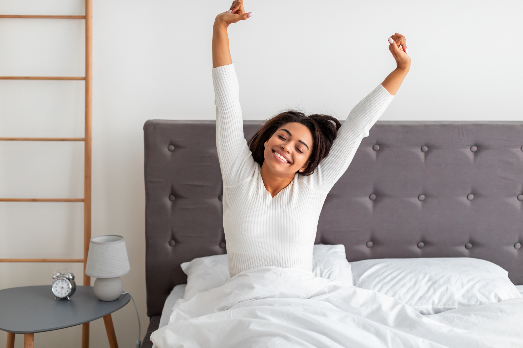 woman waking up stretching and smiling