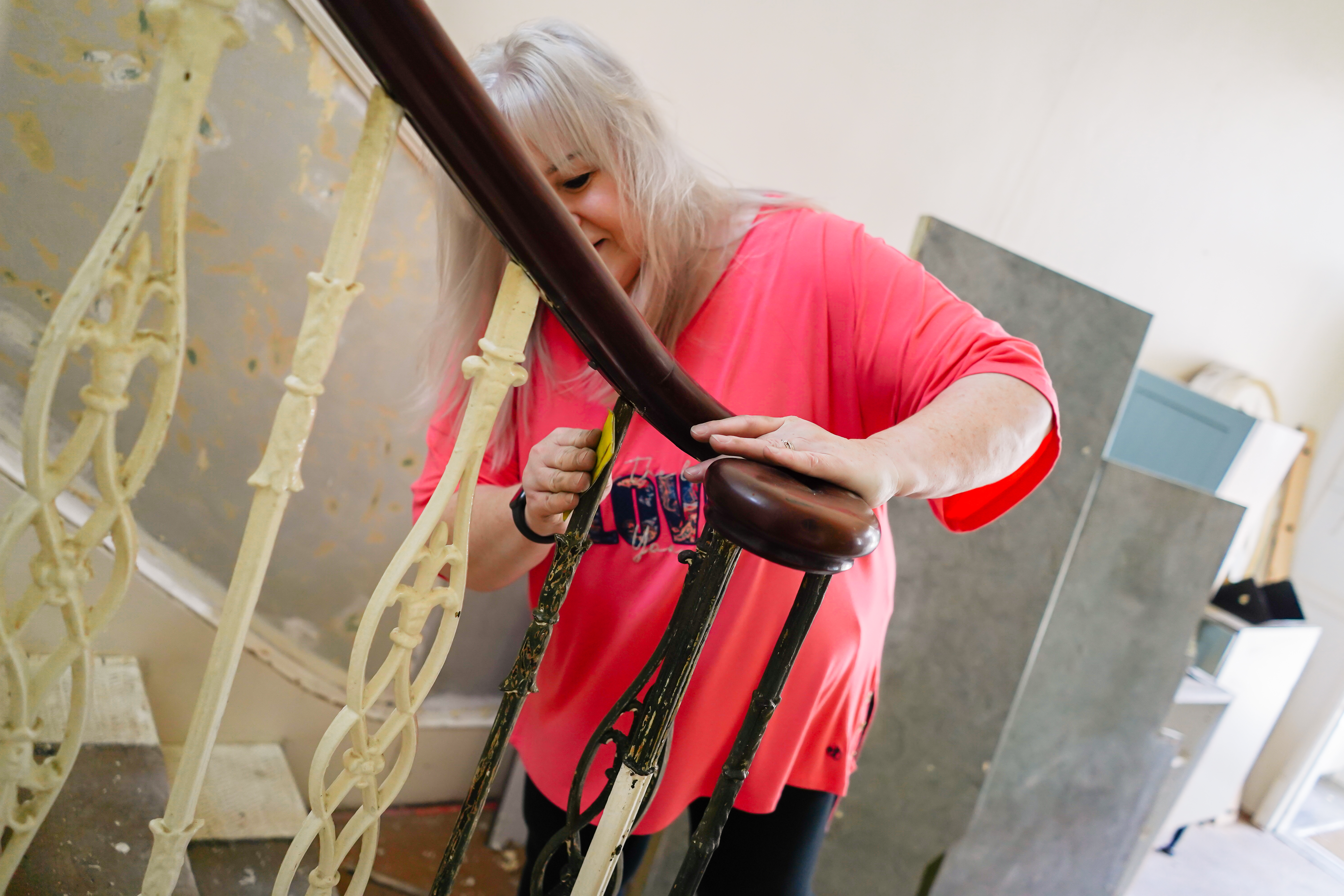 picture of a woman sanding stair rails