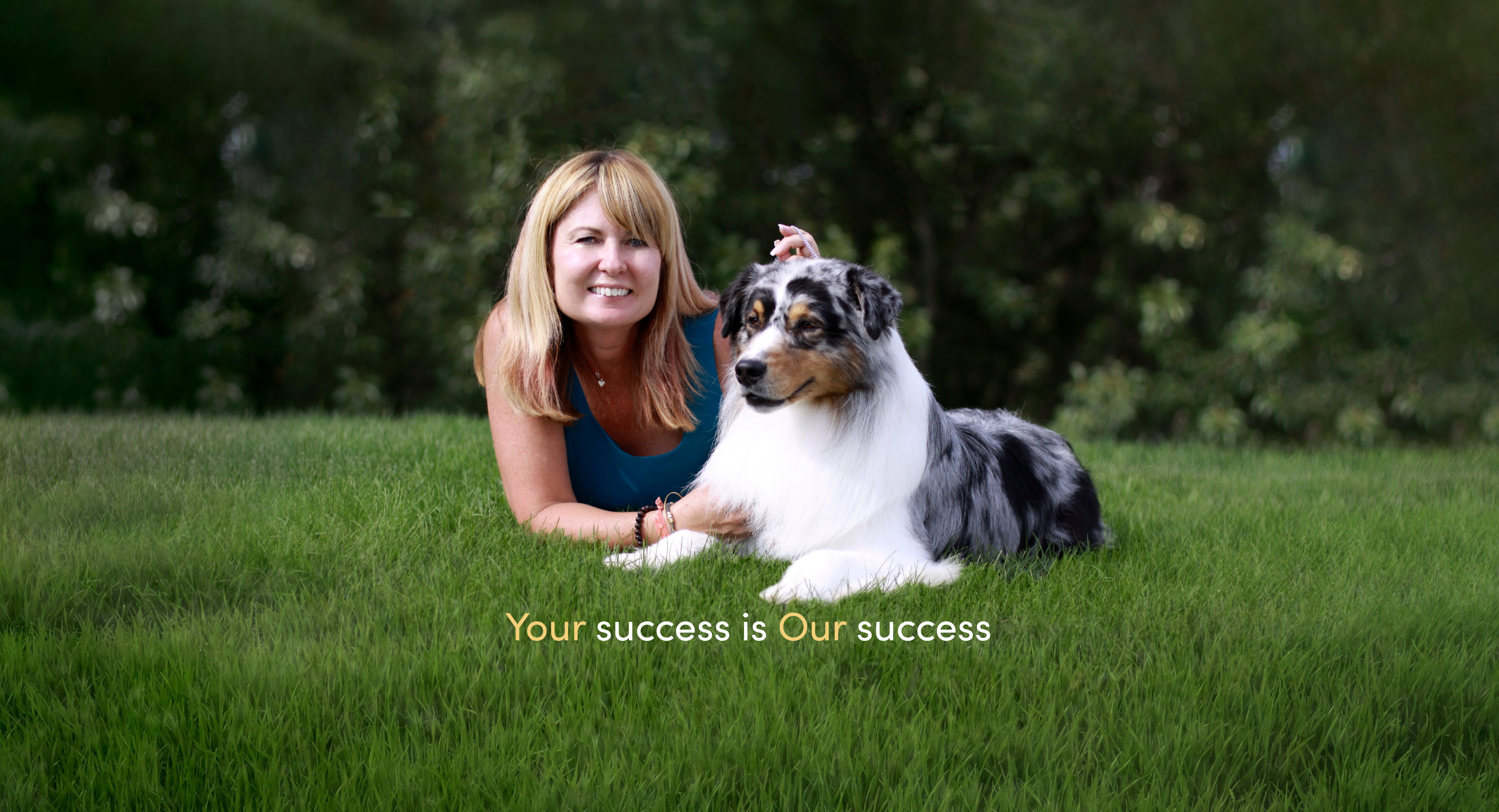 Allison lays in grass with the Australian Shepherd 